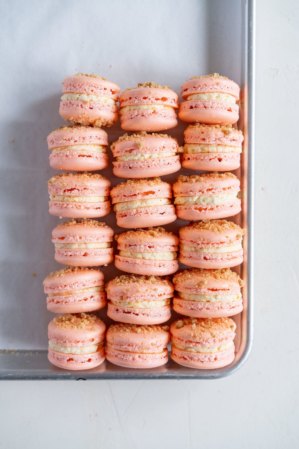 Roasted Peach Streusel Macarons - inspired by the peach cobbler, these french macarons have a roasted peach german buttercream, and a brown butter streusel crunch #macarons #peachcobbler #frenchmacaron #roastedpeach #germanbuttercream
