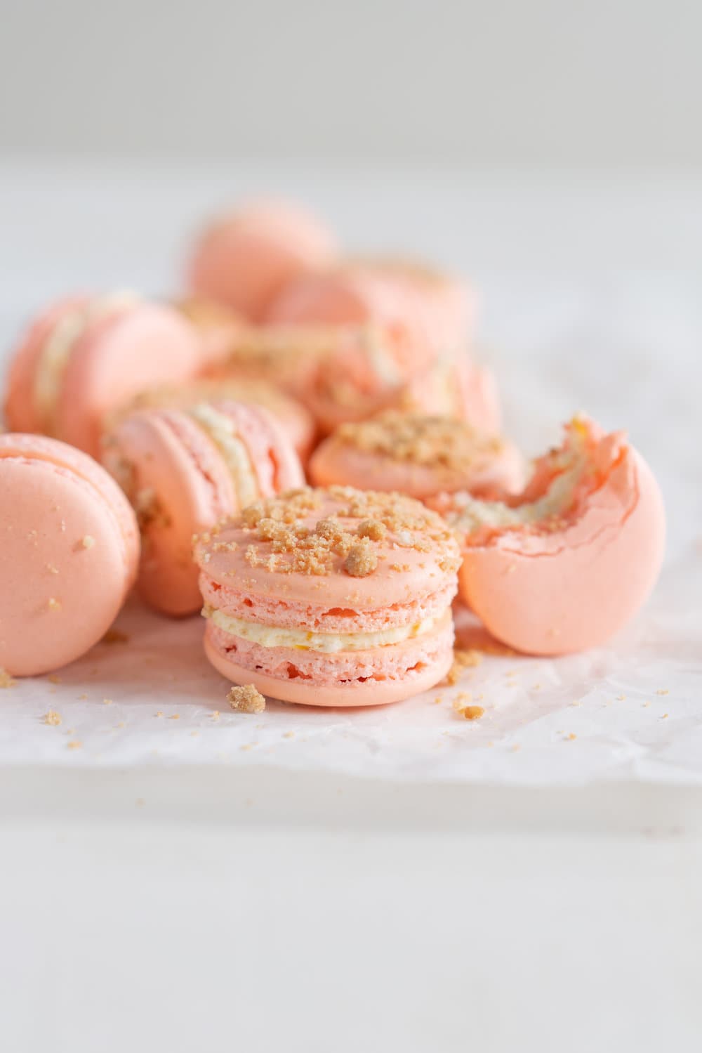 Roasted Peach Streusel Macarons - inspired by the peach cobbler, these french macarons have a roasted peach german buttercream, and a brown butter streusel crunch #macarons #peachcobbler #frenchmacaron #roastedpeach #germanbuttercream