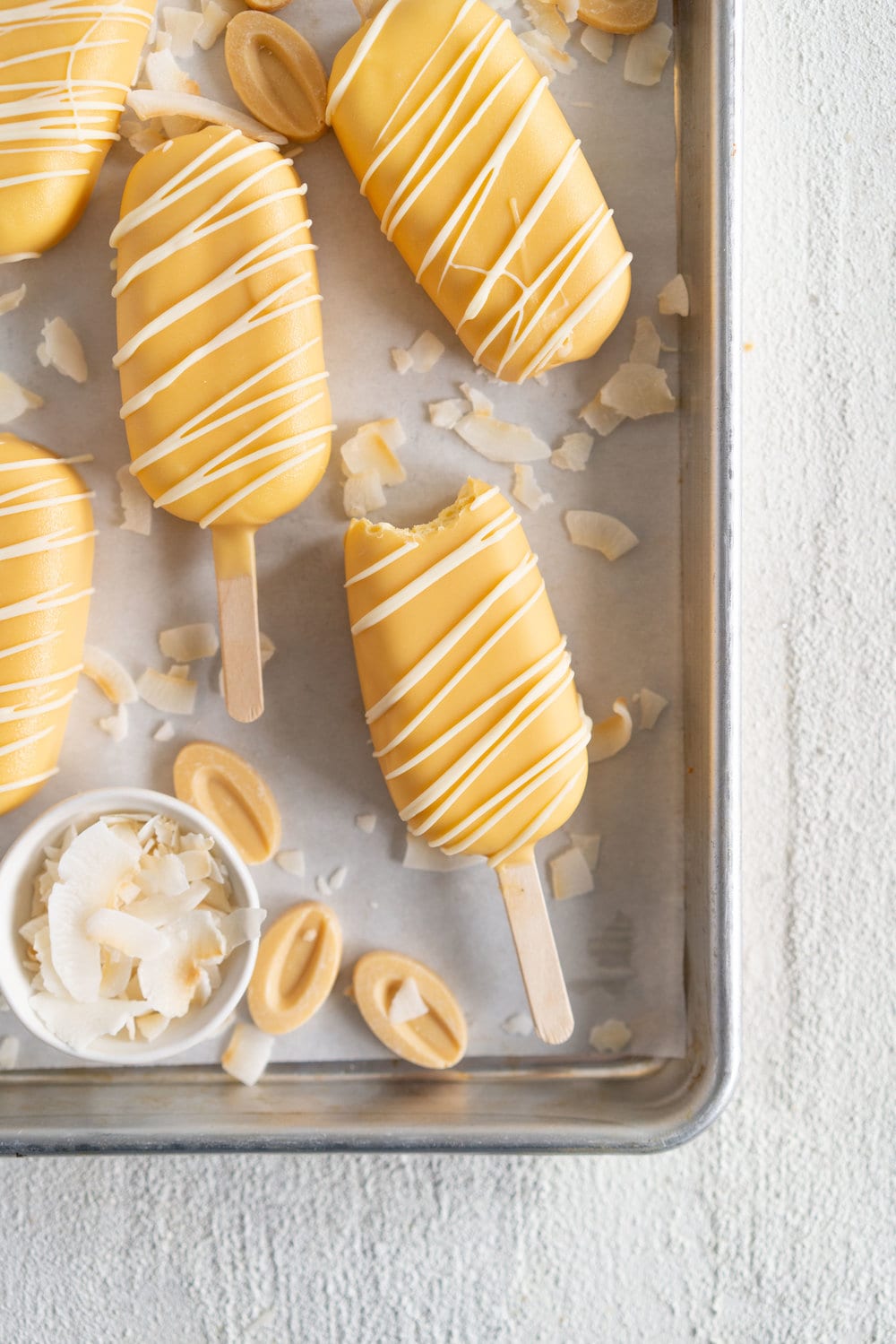 Toasted Coconut Ice Cream Pops with Passionfruit magic shell - a creamy toasted coconut ice cream is dipped in a punchy passionfruit magic shell. Quite possibly the most perfect ice cream combination you will ever come across. #passionfruit #toastedcoconut #icecreampop #icecream #magicshell