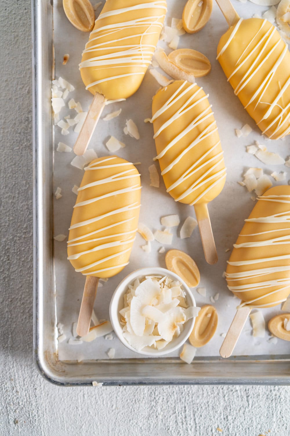 Toasted Coconut Ice Cream Pops with Passionfruit magic shell - a creamy toasted coconut ice cream is dipped in a punchy passionfruit magic shell. Quite possibly the most perfect ice cream combination you will ever come across. #passionfruit #toastedcoconut #icecreampop #icecream #magicshell