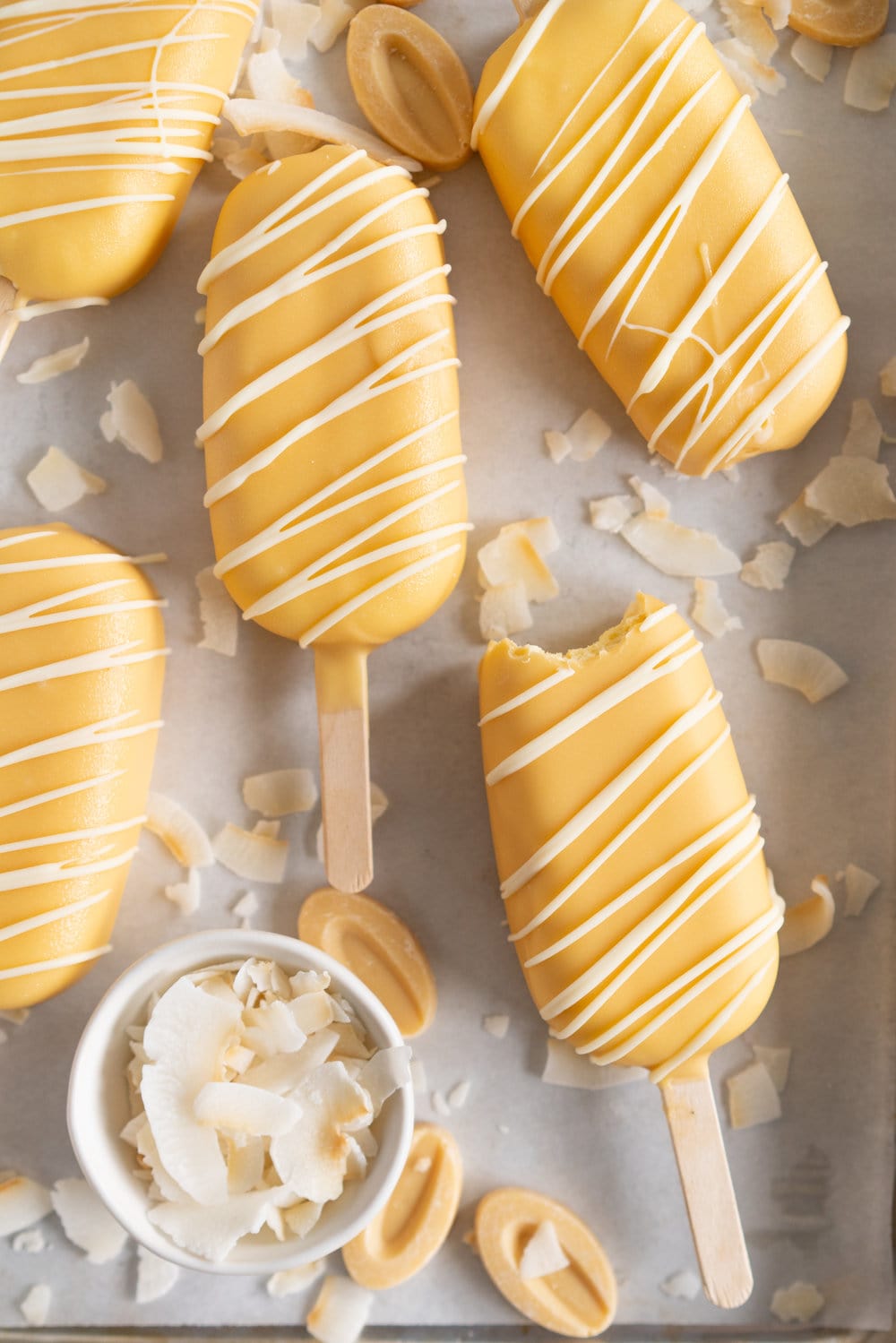 Toasted Coconut Ice Cream Pops with Passionfruit magic shell - a creamy toasted coconut ice cream is dipped in a punchy passionfruit magic shell. Quite possibly the most perfect ice cream combination you will ever come across. #passionfruit #toastedcoconut #icecreampop #icecream #magicshell