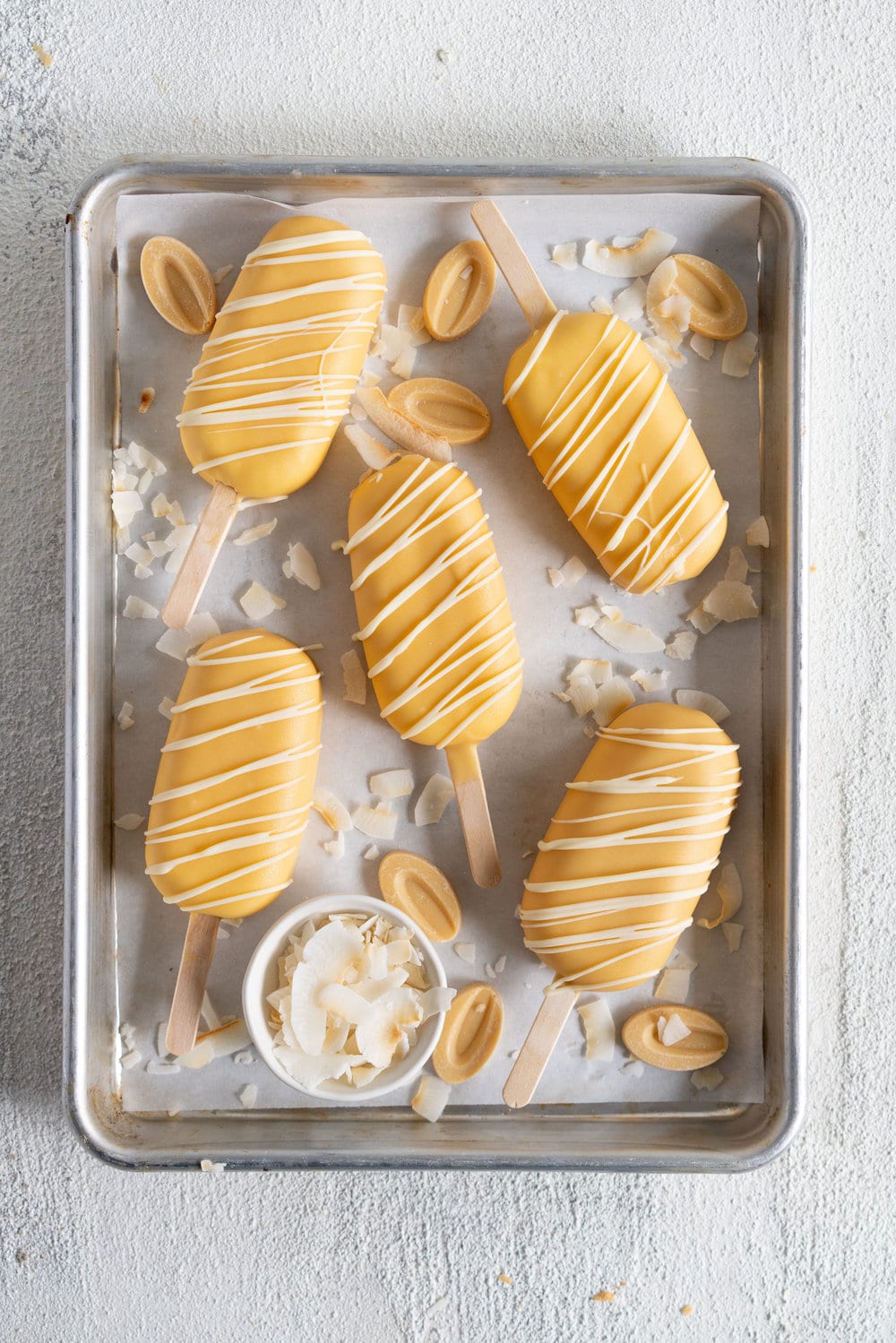 Toasted Coconut Ice Cream Pops with Passionfruit magic shell - a creamy toasted coconut ice cream is dipped in a punchy passionfruit magic shell. Quite possibly the most perfect ice cream combination you will ever come across. #passionfruit #toastedcoconut #icecreampop #icecream #magicshell