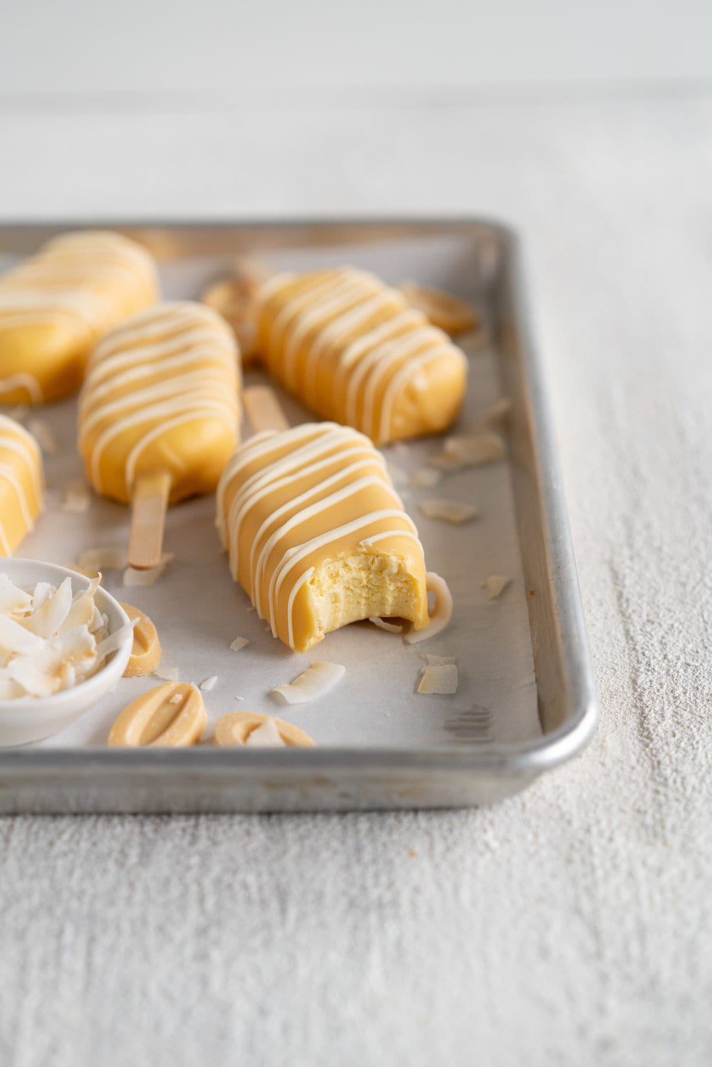 Toasted Coconut Ice Cream Pops with Passionfruit magic shell - a creamy toasted coconut ice cream is dipped in a punchy passionfruit magic shell. Quite possibly the most perfect ice cream combination you will ever come across. #passionfruit #toastedcoconut #icecreampop #icecream #magicshell