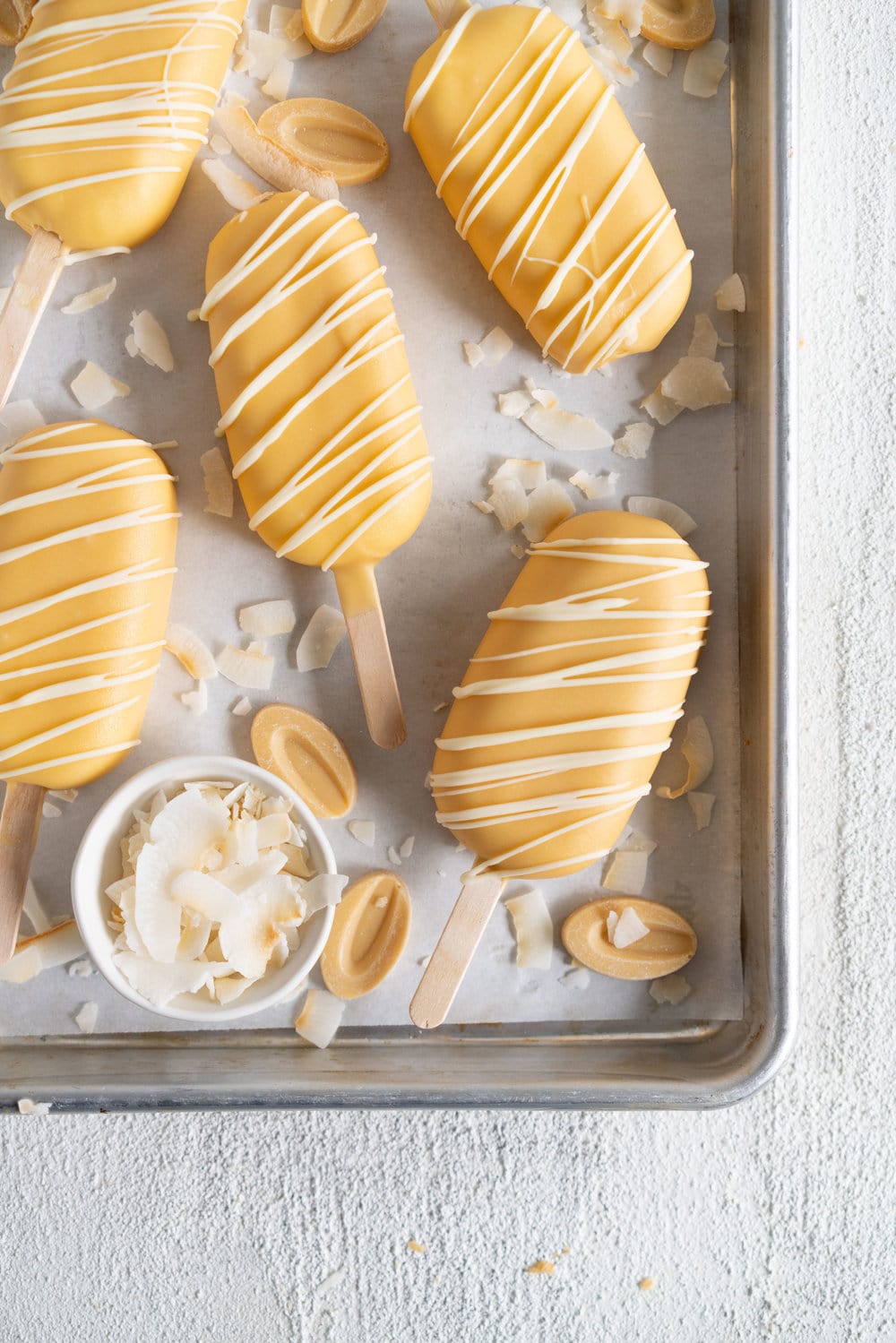 Toasted Coconut Ice Cream Pops with Passionfruit magic shell - a creamy toasted coconut ice cream is dipped in a punchy passionfruit magic shell. Quite possibly the most perfect ice cream combination you will ever come across. #passionfruit #toastedcoconut #icecreampop #icecream #magicshell