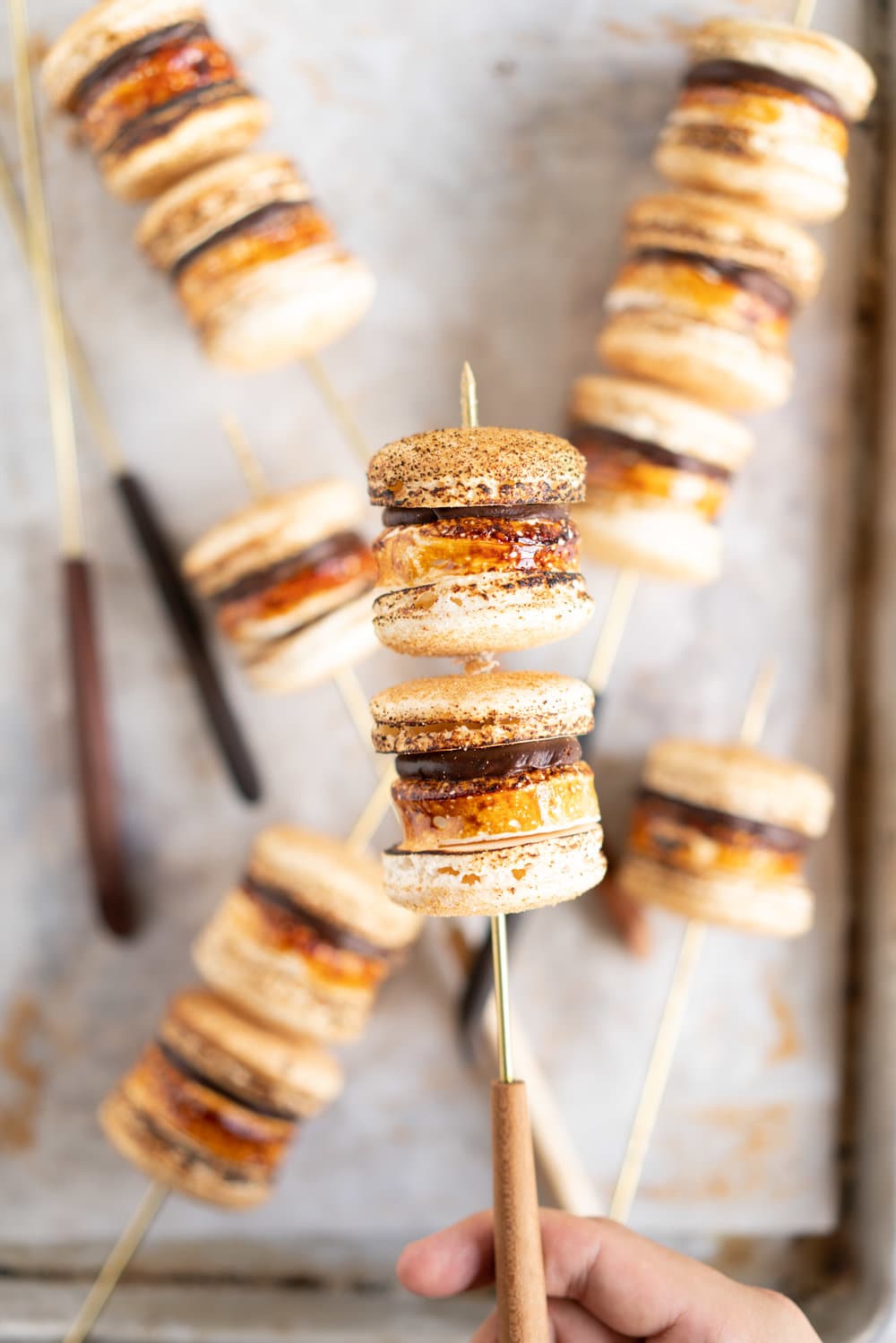 macarons on a skewer being held by a hand
