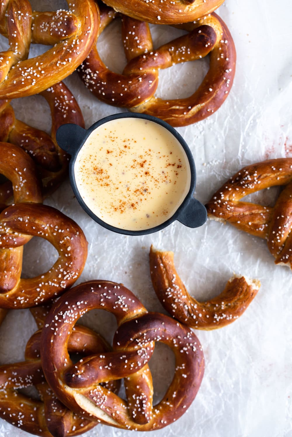 Authentic pretzels, baked until perfectly soft and golden brown, dipped in a super easy cheesy mustard dipping sauce that comes together extremely quickly. The perfect snack for a crowd. #pretzels #cheesesauce #cheesedip #americancheese #bread #homemadepretzels #bakingsodadip