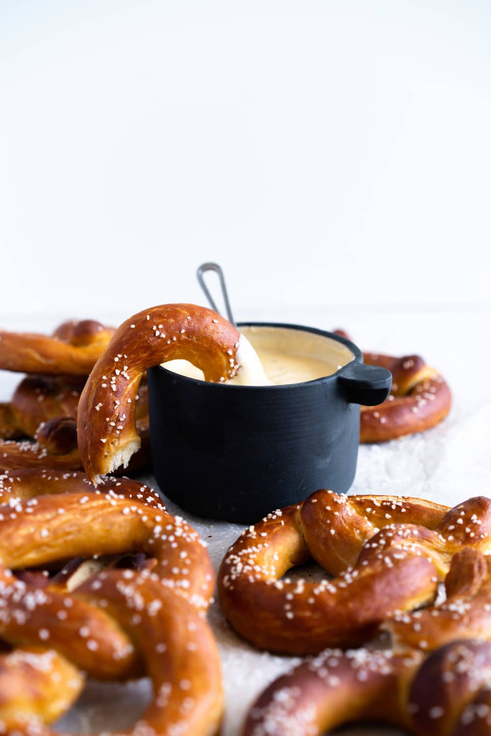 Authentic pretzels, baked until perfectly soft and golden brown, dipped in a super easy cheesy mustard dipping sauce that comes together extremely quickly. The perfect snack for a crowd. #pretzels #cheesesauce #cheesedip #americancheese #bread #homemadepretzels #bakingsodadip
