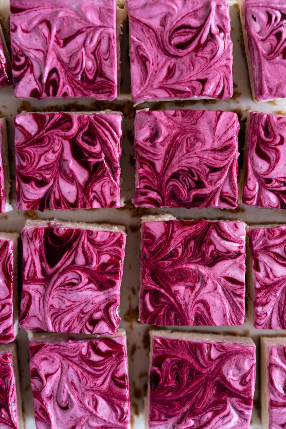 No Bake Mixed Berry Cheesecake Bars - delicious graham cracker crust, topped with a silky vanilla bean no bake filling, and finished with a beautiful marbled swirl of mixed berry coulis. perfect No bake, low effort dessert for any time of the year. #nobake #cheesecake #cheesecakebars #mixedberry #coulis