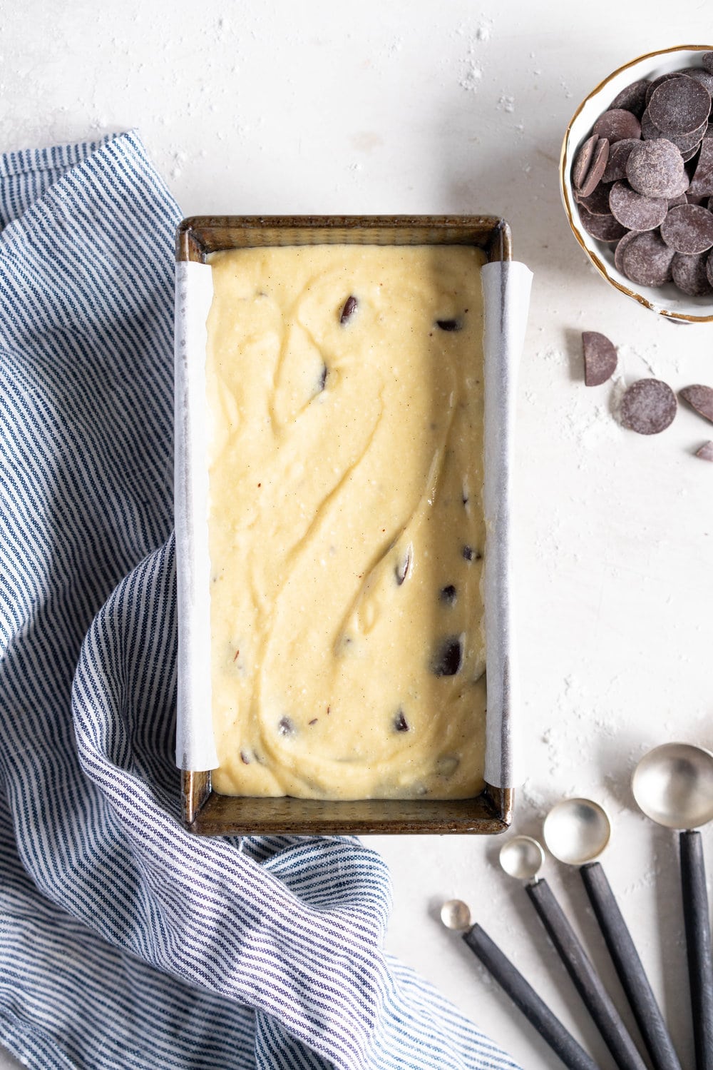 Chocolate Chunk Olive Oil Ricotta cake with Dark Chocolate buttercream - this cake is flavoursome from the olive oil, with a perfect crumb from the ricotta in the batter. It is studded with dark chocolate chunks throughout, and finished with a silky smooth dark chocolate buttercream. The perfect elevated loaf cake. #loafcake #poundcake #ricottacake