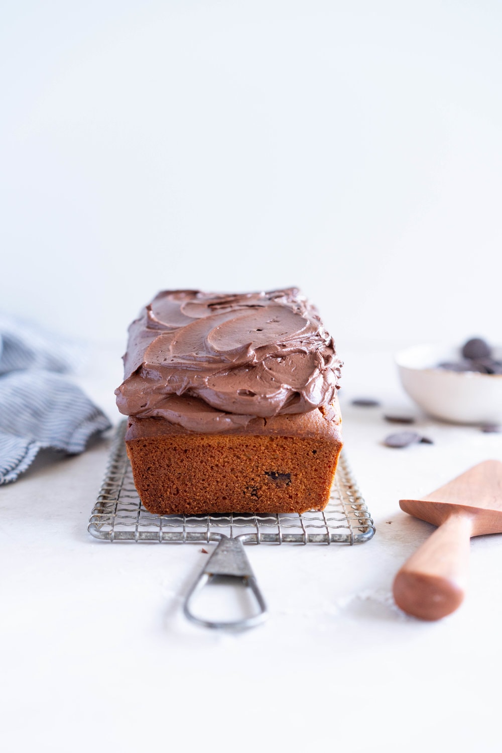 Chocolate Chunk Olive Oil Ricotta cake with Dark Chocolate buttercream - this cake is flavoursome from the olive oil, with a perfect crumb from the ricotta in the batter. It is studded with dark chocolate chunks throughout, and finished with a silky smooth dark chocolate buttercream. The perfect elevated loaf cake. #loafcake #poundcake #ricottacake