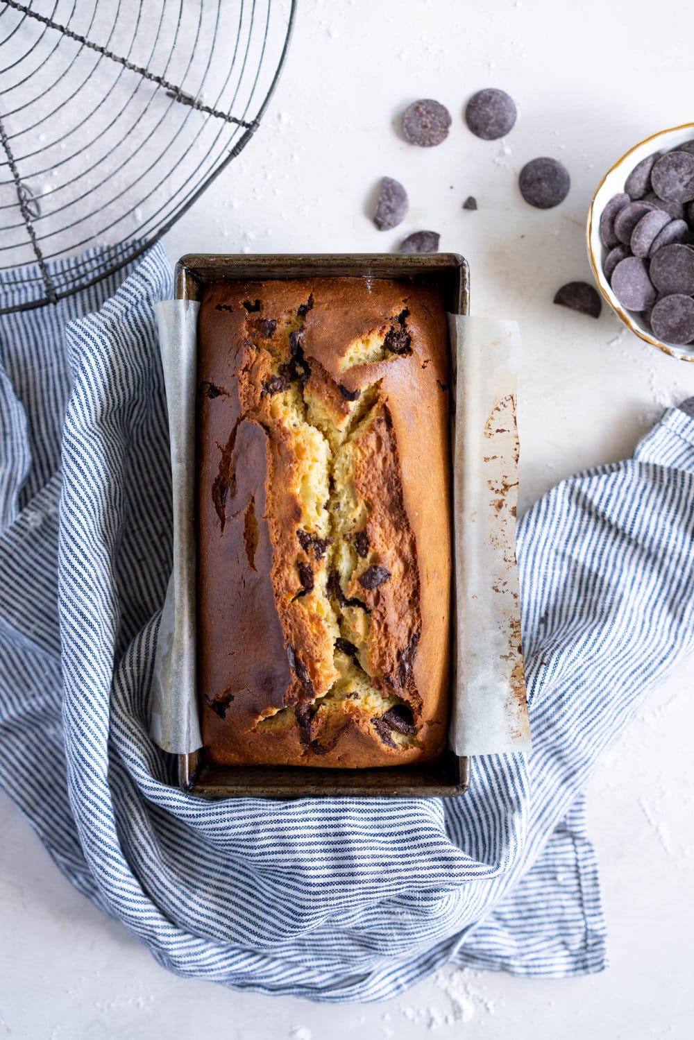 Chocolate Chunk Olive Oil Ricotta cake with Dark Chocolate buttercream - this cake is flavoursome from the olive oil, with a perfect crumb from the ricotta in the batter. It is studded with dark chocolate chunks throughout, and finished with a silky smooth dark chocolate buttercream. The perfect elevated loaf cake. #loafcake #poundcake #ricottacake