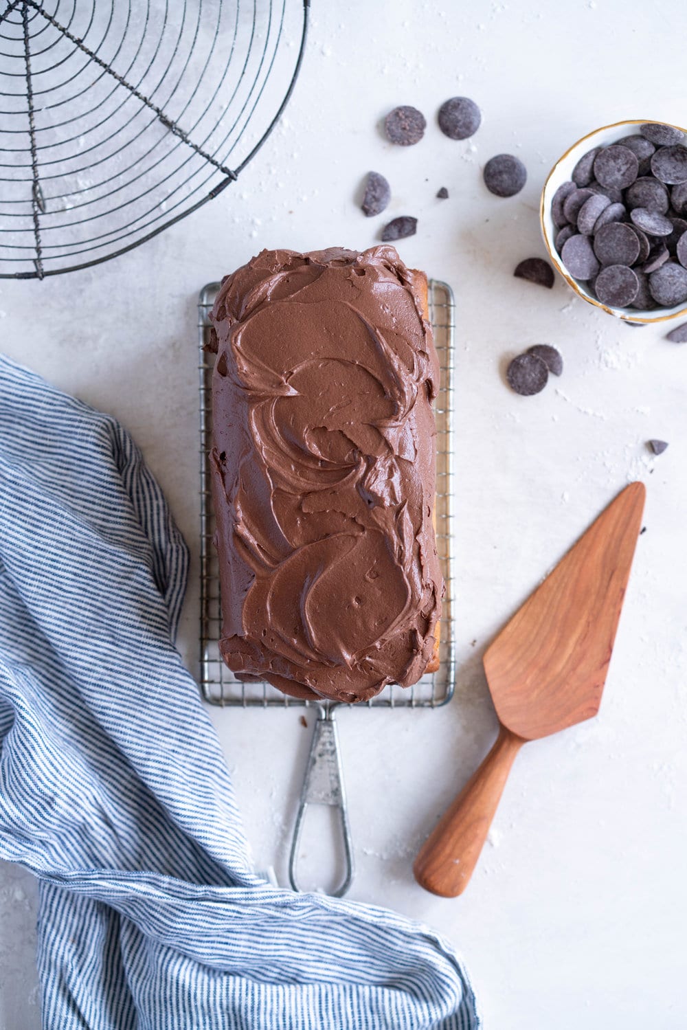 Chocolate Chunk Olive Oil Ricotta cake with Dark Chocolate buttercream - this cake is flavoursome from the olive oil, with a perfect crumb from the ricotta in the batter. It is studded with dark chocolate chunks throughout, and finished with a silky smooth dark chocolate buttercream. The perfect elevated loaf cake. #loafcake #poundcake #ricottacake