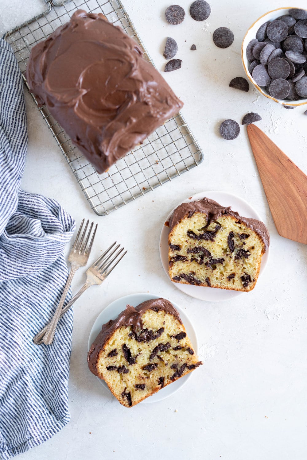 Chocolate Chunk Olive Oil Ricotta cake with Dark Chocolate buttercream - this cake is flavoursome from the olive oil, with a perfect crumb from the ricotta in the batter. It is studded with dark chocolate chunks throughout, and finished with a silky smooth dark chocolate buttercream. The perfect elevated loaf cake. #loafcake #poundcake #ricottacake
