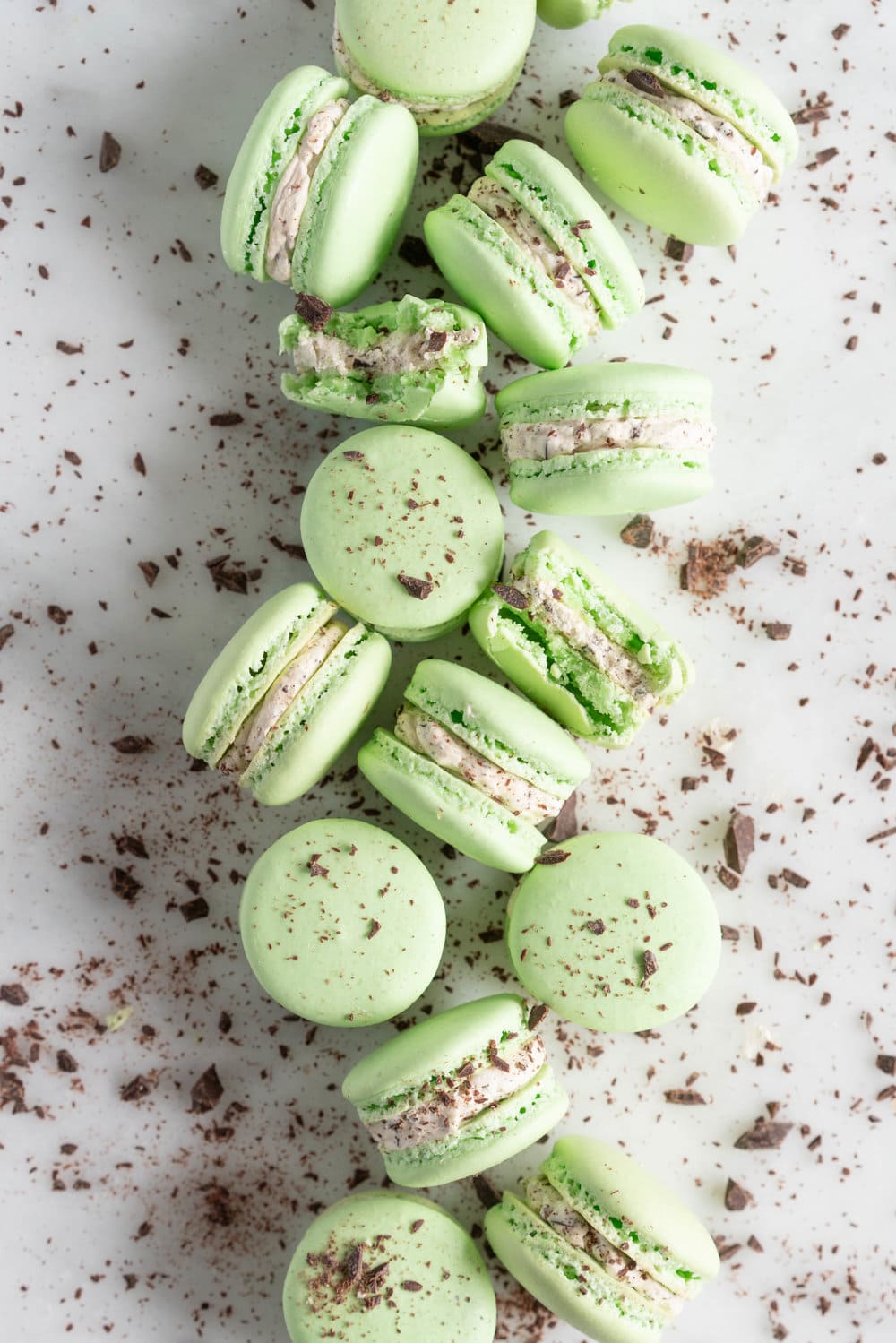 Mint Chocolate Chip Macarons with German buttercream. Delicate French macaron shells are sandwiched together by a mint chocolate chip german buttercream that tastes just like ice cream! #mintchocolatechip #mintchip #frenchmacarons #macarons #recipe #howtomake