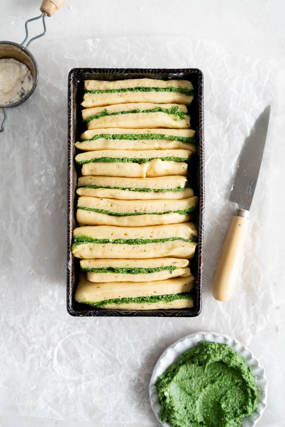 Spinach, Feta and Basil pesto Pull-apart bread. This pull apart loaf is super easy to put together, while being very impressive at the same time! A simple dough is filled with a spinach, feta and basil pesto filling, then cut into rectangles and layered into a loaf tin for the perfect pull apart bread. #pullapartbread #basilpestobread #spinachloaf