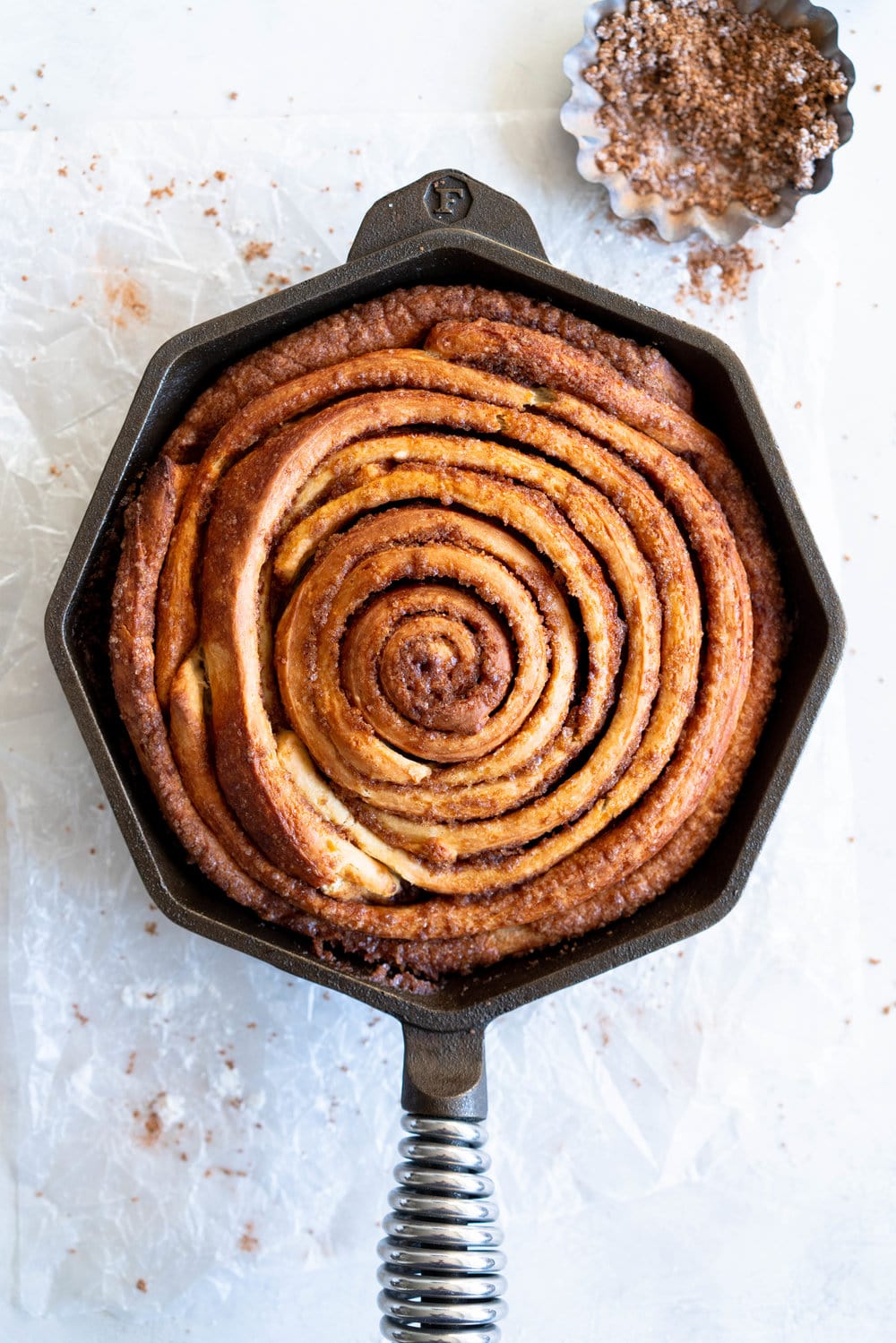 Giant Skillet Cinnamon Roll with Cream Cheese Icing - from Holiday and Celebration bread in five minutes a day. No knead brioche is covered in cinnamon sugar and rolled into a giant cinnamon roll - the most amazing twist on the traditional roll, and perfect for Christmas morning.