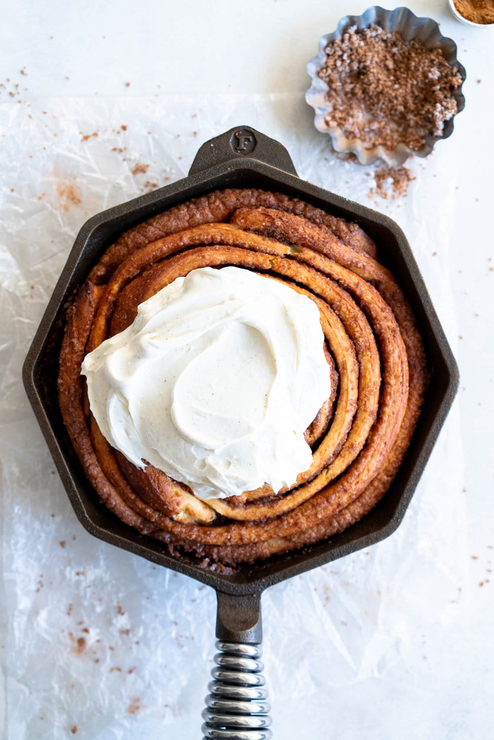 Giant Skillet Cinnamon Roll with Cream Cheese Icing - from Holiday and Celebration bread in five minutes a day. No knead brioche is covered in cinnamon sugar and rolled into a giant cinnamon roll - the most amazing twist on the traditional roll, and perfect for Christmas morning.