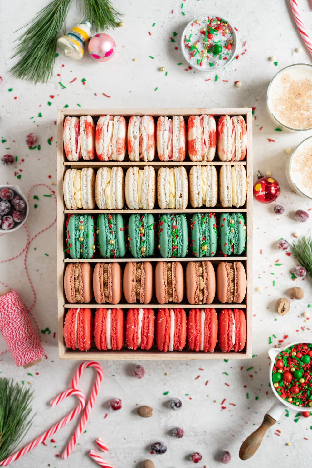 The Ultimate Christmas Macaron box - a cute, gluten free twist on the traditional cookie box. This cookie box is filled with the flavours of christmas - Candy Cane, Eggnog, Christmasfetti, Gingerbread, and cranberry. Each macaron is filled with a delicious complementary filling - ranging from american buttercream to German buttercream. This macaron box would make the perfect homemade gift. Grab the recipes now!