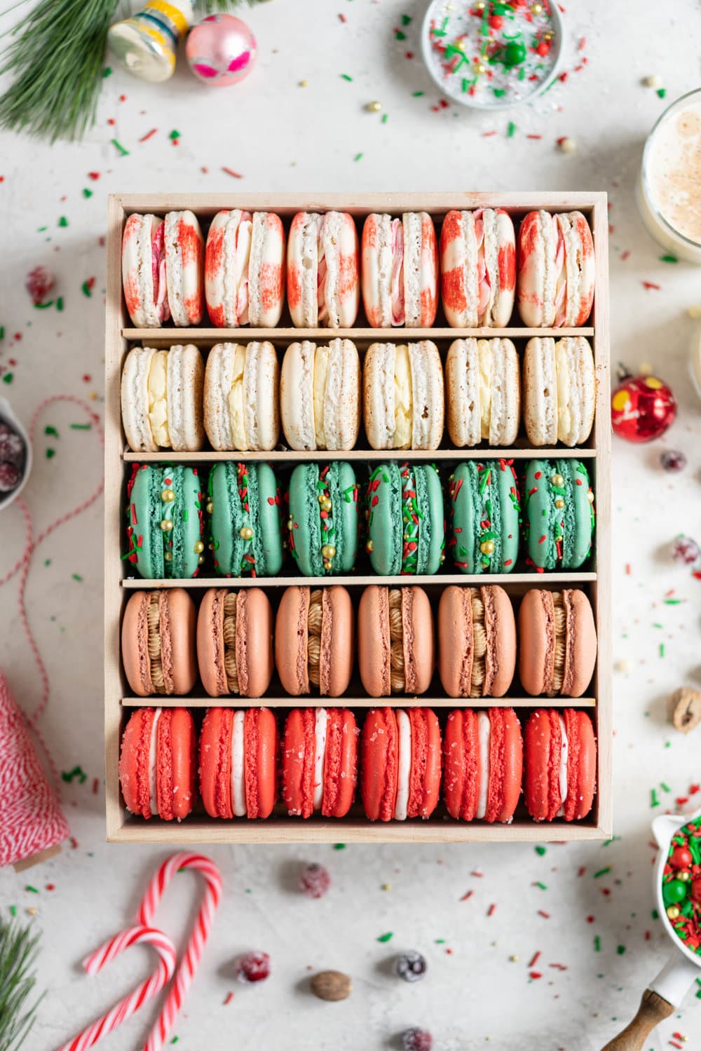 The Ultimate Christmas Macaron box - a cute, gluten free twist on the traditional cookie box. This cookie box is filled with the flavours of christmas - Candy Cane, Eggnog, Christmasfetti, Gingerbread, and cranberry. Each macaron is filled with a delicious complementary filling - ranging from american buttercream to German buttercream. This macaron box would make the perfect homemade gift. Grab the recipes now!