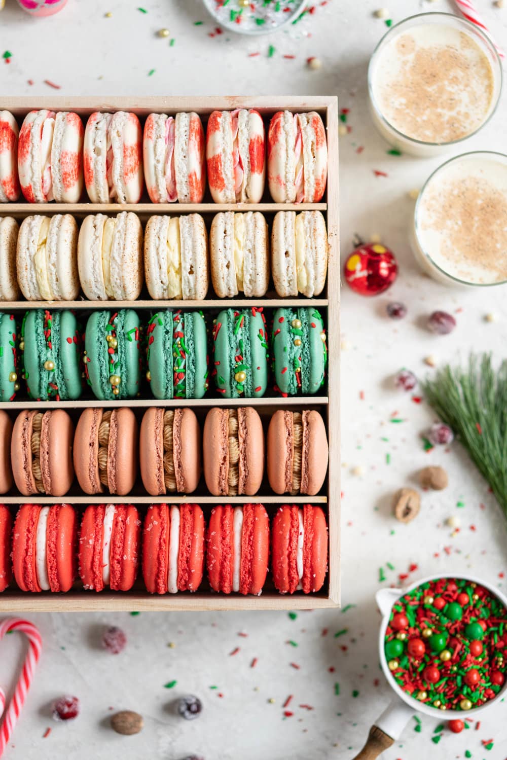 The Ultimate Christmas Macaron box - a cute, gluten free twist on the traditional cookie box. This cookie box is filled with the flavours of christmas - Candy Cane, Eggnog, Christmasfetti, Gingerbread, and cranberry. Each macaron is filled with a delicious complementary filling - ranging from american buttercream to German buttercream. This macaron box would make the perfect homemade gift. Grab the recipes now!