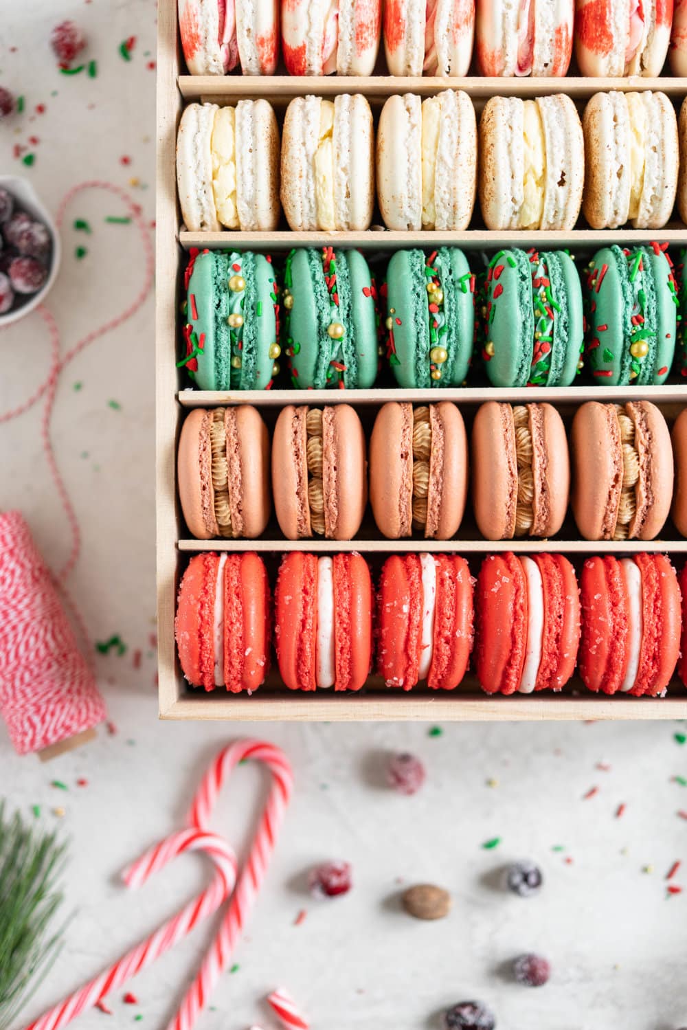 The Ultimate Christmas Macaron box - a cute, gluten free twist on the traditional cookie box. This cookie box is filled with the flavours of christmas - Candy Cane, Eggnog, Christmasfetti, Gingerbread, and cranberry. Each macaron is filled with a delicious complementary filling - ranging from american buttercream to German buttercream. This macaron box would make the perfect homemade gift. Grab the recipes now!