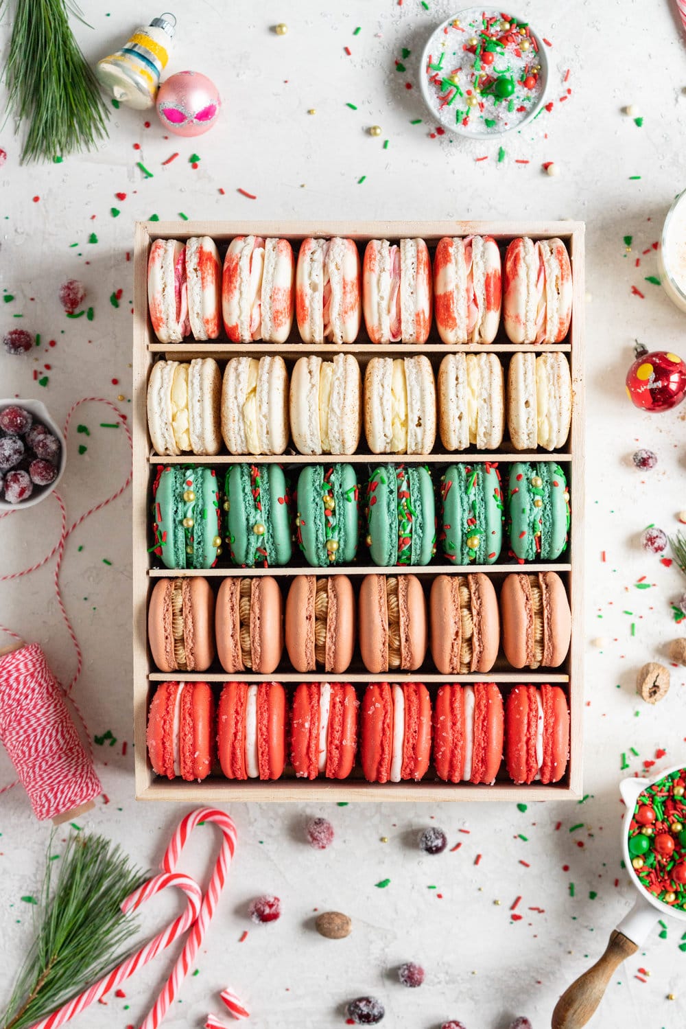 The Ultimate Christmas Macaron box - a cute, gluten free twist on the traditional cookie box. This cookie box is filled with the flavours of christmas - Candy Cane, Eggnog, Christmasfetti, Gingerbread, and cranberry. Each macaron is filled with a delicious complementary filling - ranging from american buttercream to German buttercream. This macaron box would make the perfect homemade gift. Grab the recipes now!