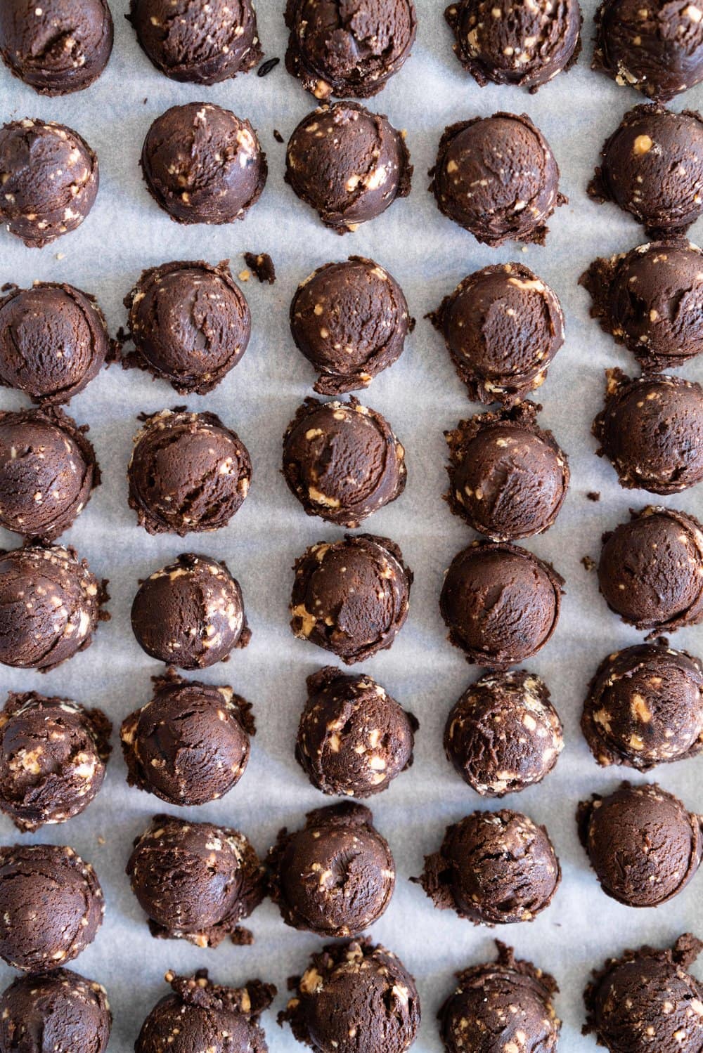 Caramelised White Chocolate Brownie Cookies with Salted Dark Chocolate German Buttercream. Perfect tiny mouthfuls of soft chocolate brownie cookie filled with caramelised white chocolate specks, and sandwiched with silky buttercream. These are bound to become your new favourite. #sandwichcookies #browniecookie #germanbuttercream