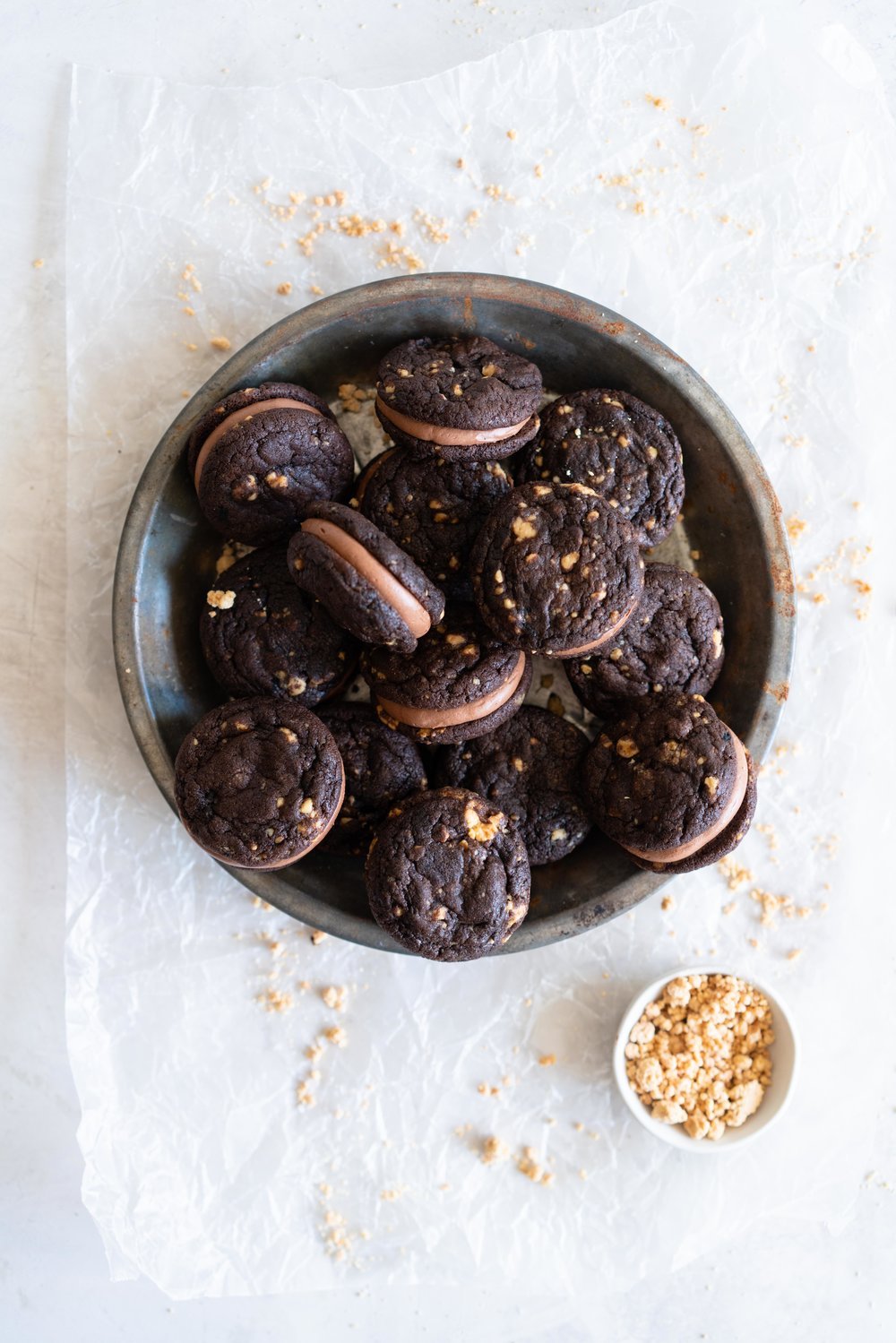 Caramelised White Chocolate Brownie Cookies with Salted Dark Chocolate German Buttercream. Perfect tiny mouthfuls of soft chocolate brownie cookie filled with caramelised white chocolate specks, and sandwiched with silky buttercream. These are bound to become your new favourite. #sandwichcookies #browniecookie #germanbuttercream