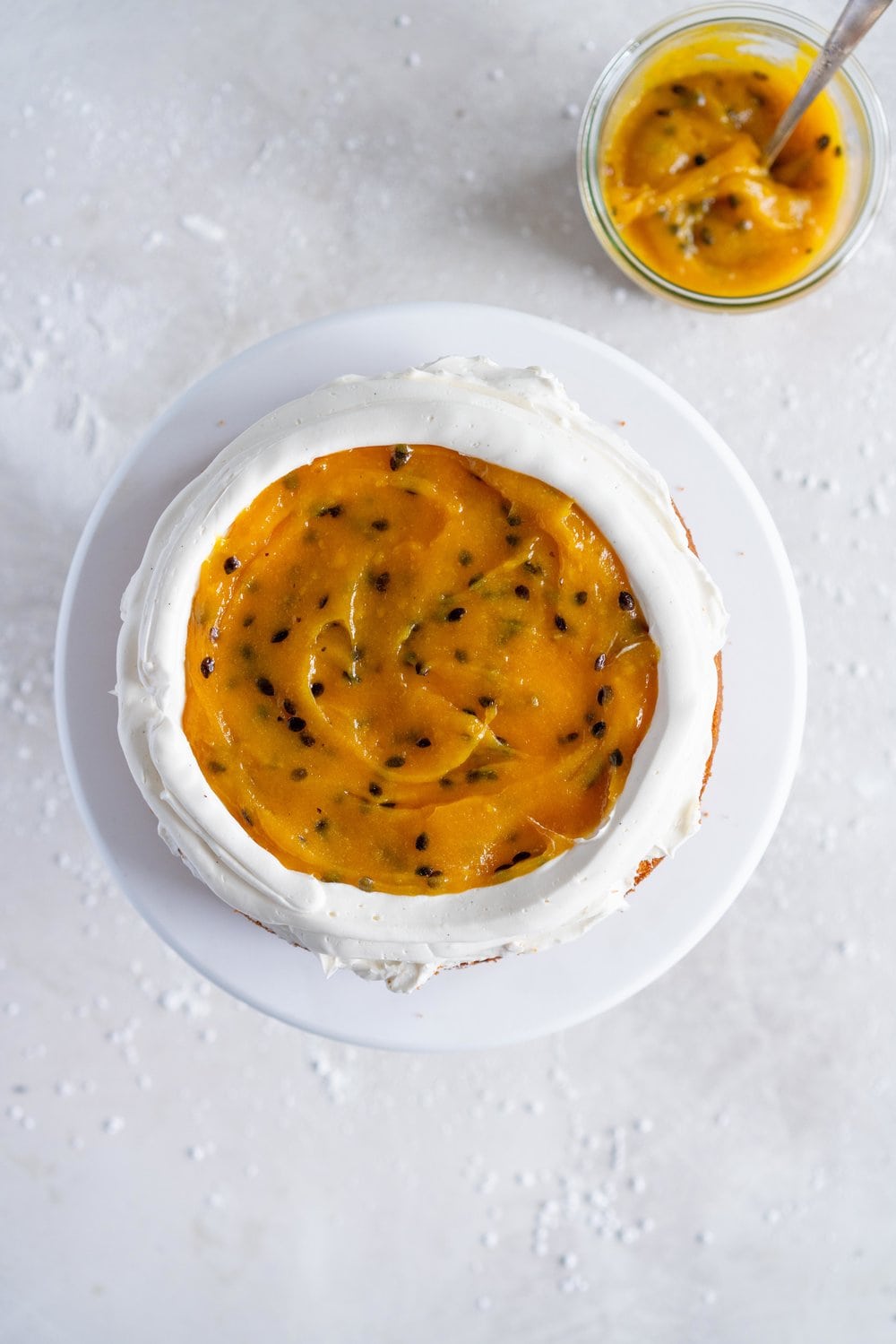 Vanilla Layer Cake with Passionfruit Curd and Vanilla Swiss Meringue Buttercream. Perfect for any occasion - layers of vanilla cake are sandwiched with a silky vanilla bean swiss meringue buttercream, and filled with a tangy, creamy passionfruit curd. #layercake #passionfruitcake