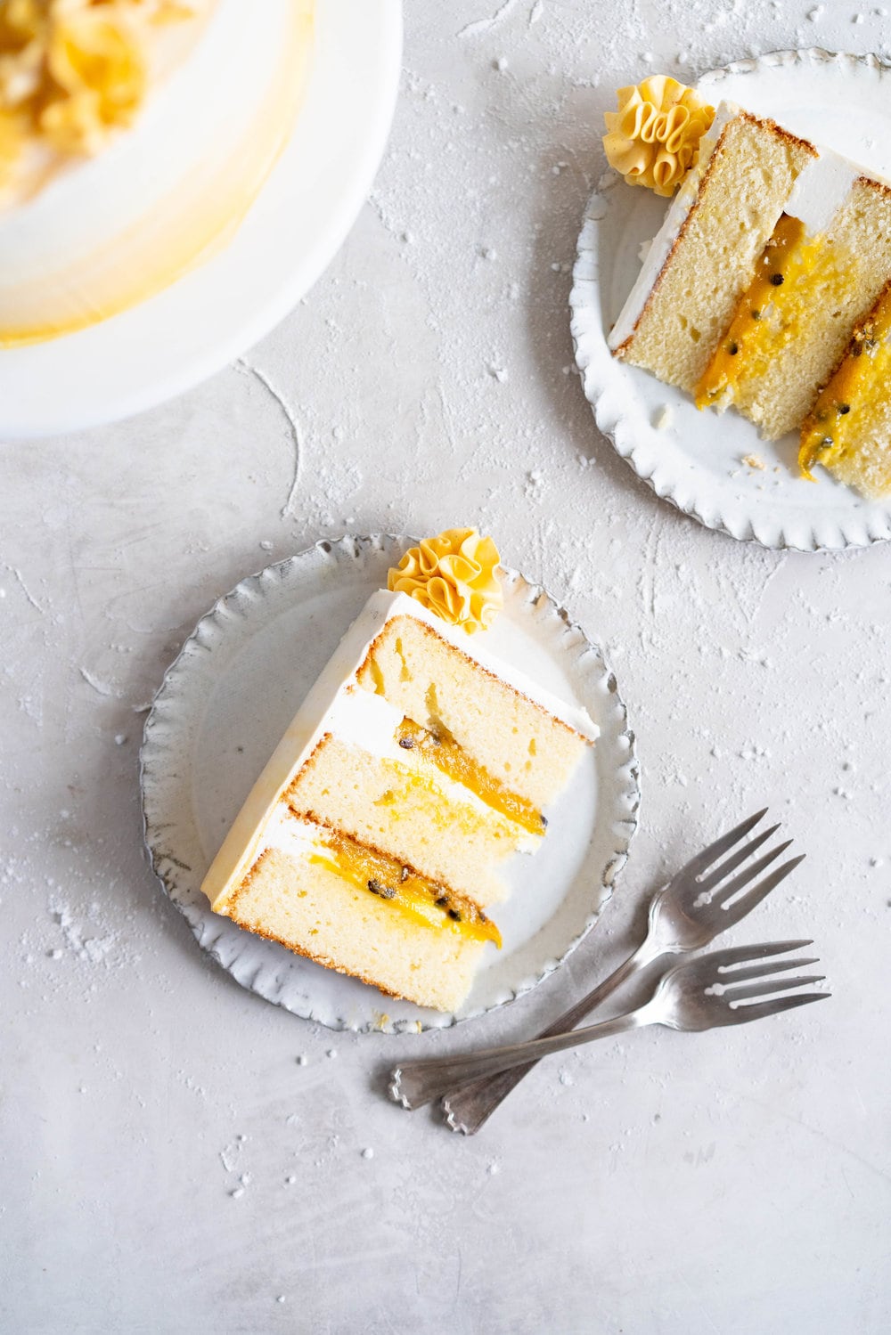 Vanilla Layer Cake with Passionfruit Curd and Vanilla Swiss Meringue Buttercream. Perfect for any occasion - layers of vanilla cake are sandwiched with a silky vanilla bean swiss meringue buttercream, and filled with a tangy, creamy passionfruit curd. #layercake #passionfruitcake