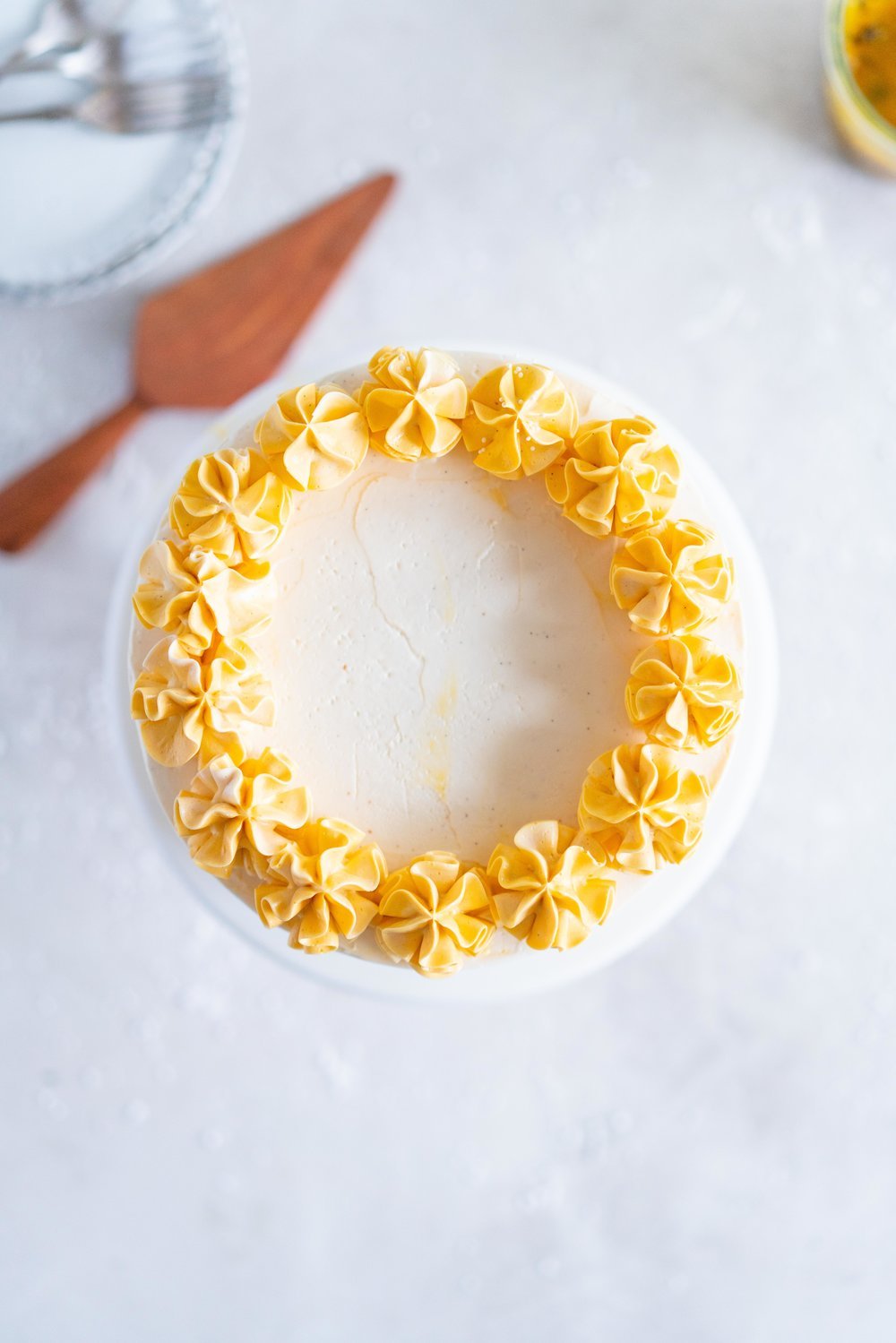 Vanilla Layer Cake with Passionfruit Curd and Vanilla Swiss Meringue Buttercream. Perfect for any occasion - layers of vanilla cake are sandwiched with a silky vanilla bean swiss meringue buttercream, and filled with a tangy, creamy passionfruit curd. #layercake #passionfruitcake