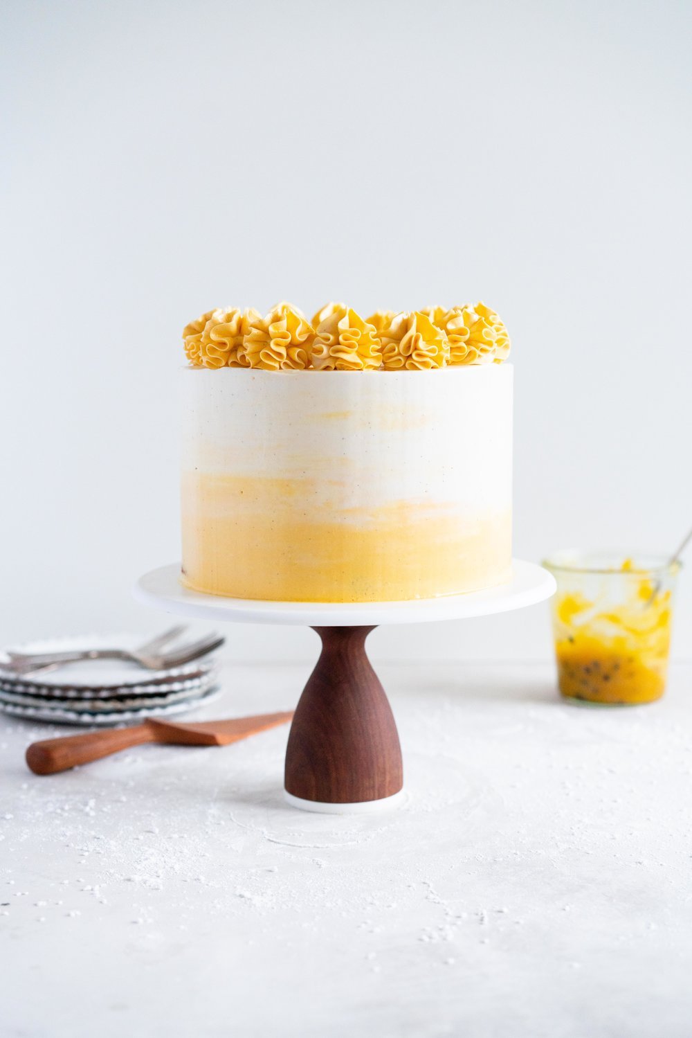 Vanilla Layer Cake with Passionfruit Curd and Vanilla Swiss Meringue Buttercream. Perfect for any occasion - layers of vanilla cake are sandwiched with a silky vanilla bean swiss meringue buttercream, and filled with a tangy, creamy passionfruit curd. #layercake #passionfruitcake