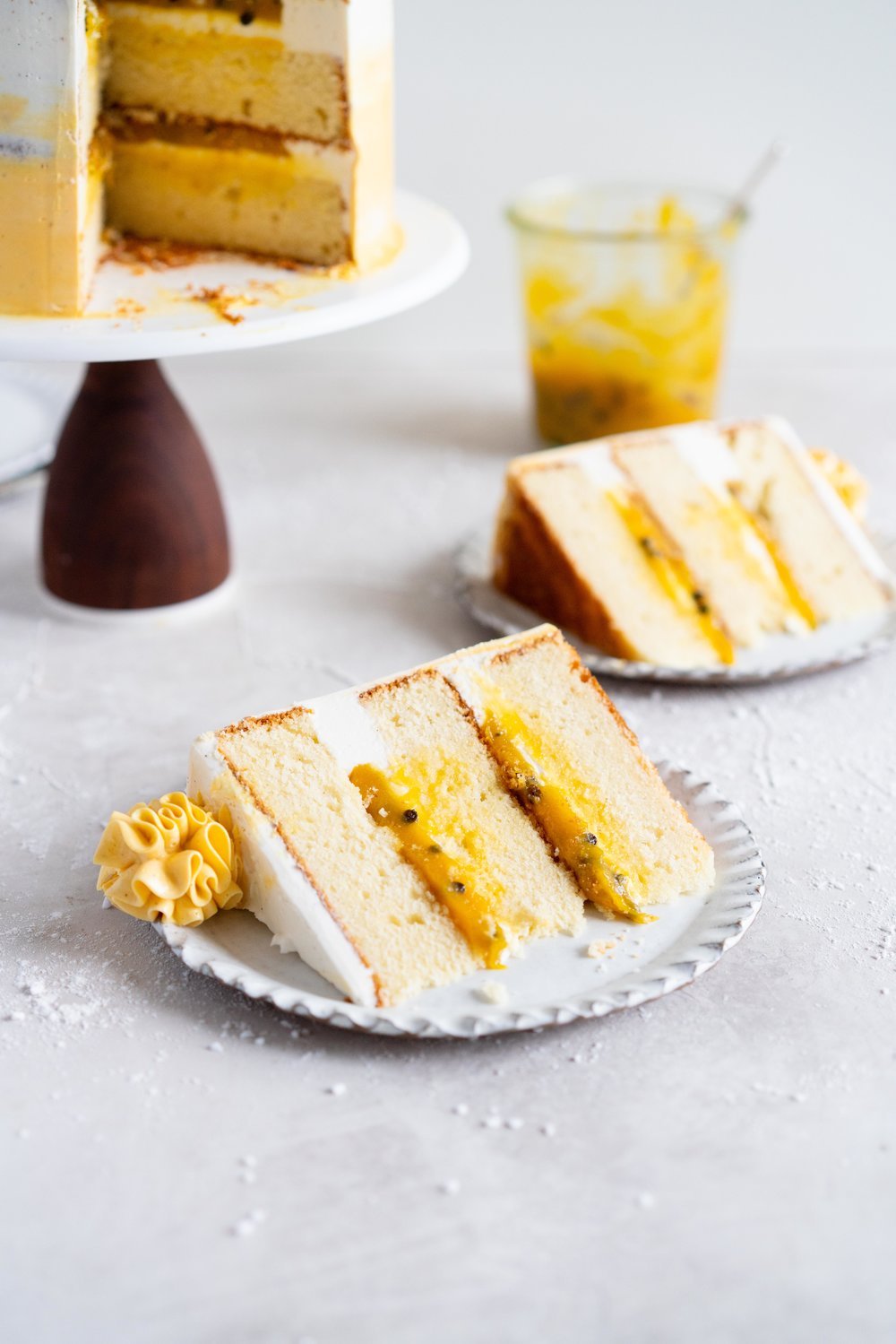 Vanilla Layer Cake with Passionfruit Curd and Vanilla Swiss Meringue Buttercream. Perfect for any occasion - layers of vanilla cake are sandwiched with a silky vanilla bean swiss meringue buttercream, and filled with a tangy, creamy passionfruit curd. #layercake #passionfruitcake