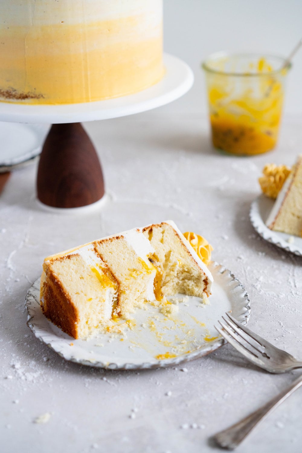 Vanilla Layer Cake with Passionfruit Curd and Vanilla Swiss Meringue Buttercream. Perfect for any occasion - layers of vanilla cake are sandwiched with a silky vanilla bean swiss meringue buttercream, and filled with a tangy, creamy passionfruit curd. #layercake #passionfruitcake