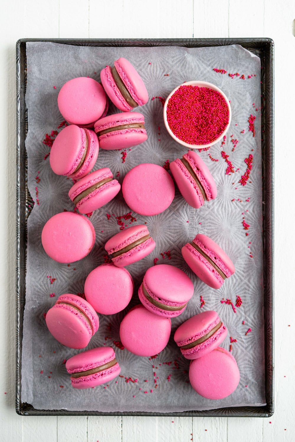 Raspberry and Dark Chocolate Macarons - A classic pink shell, filled with a homemade raspberry quick jam, and a silky Dark chocolate swiss meringue buttercream, deepened with a little black cocoa. These are a classic valentine's day pairing, and would be perfect as a gift, but would also make an amazing anytime treat for a chocolate or berry lover. #frenchmacaron #valentinesmacaron