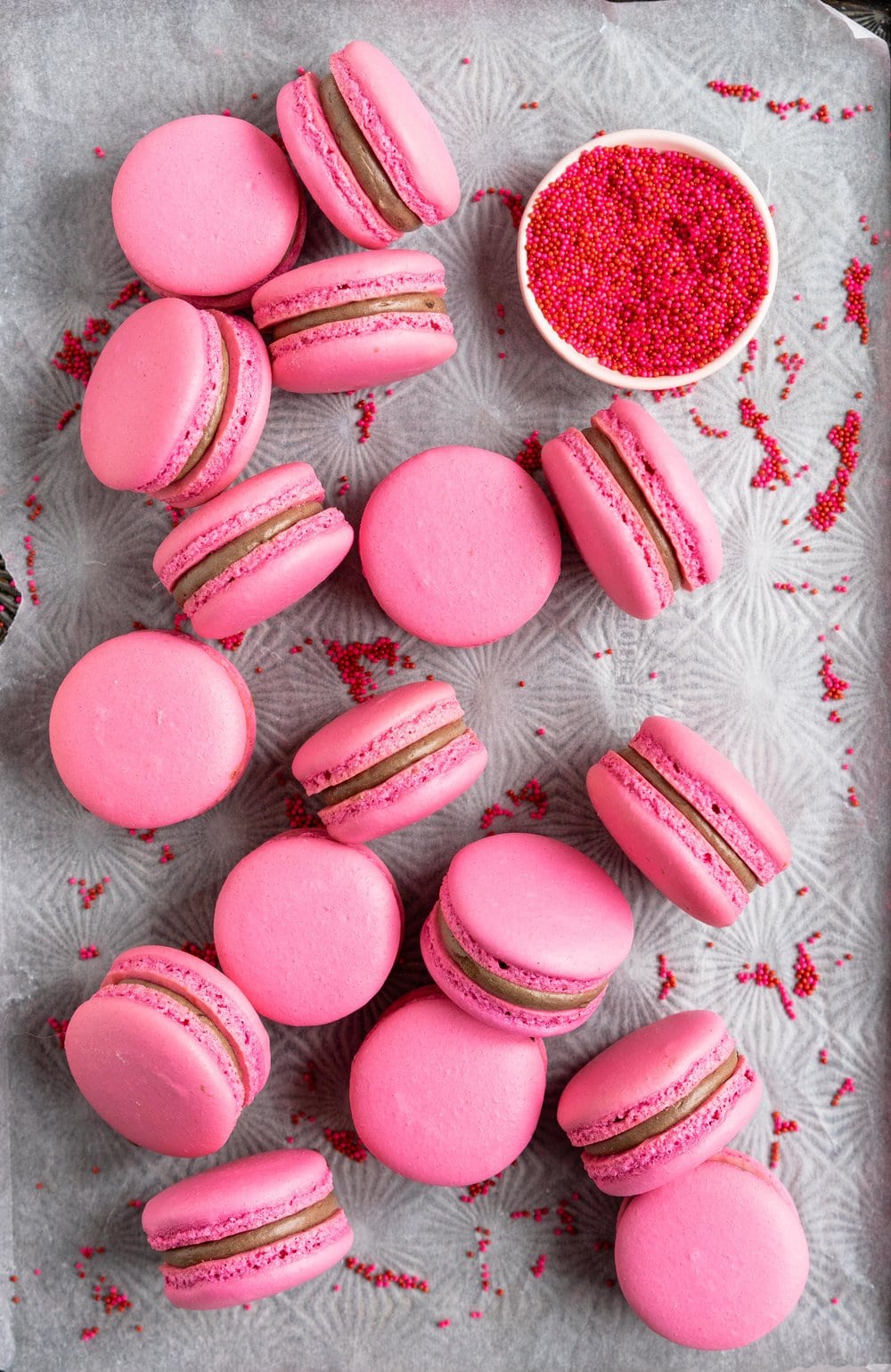 Raspberry and Dark Chocolate Macarons - A classic pink shell, filled with a homemade raspberry quick jam, and a silky Dark chocolate swiss meringue buttercream, deepened with a little black cocoa. These are a classic valentine's day pairing, and would be perfect as a gift, but would also make an amazing anytime treat for a chocolate or berry lover. #frenchmacaron #valentinesmacaron