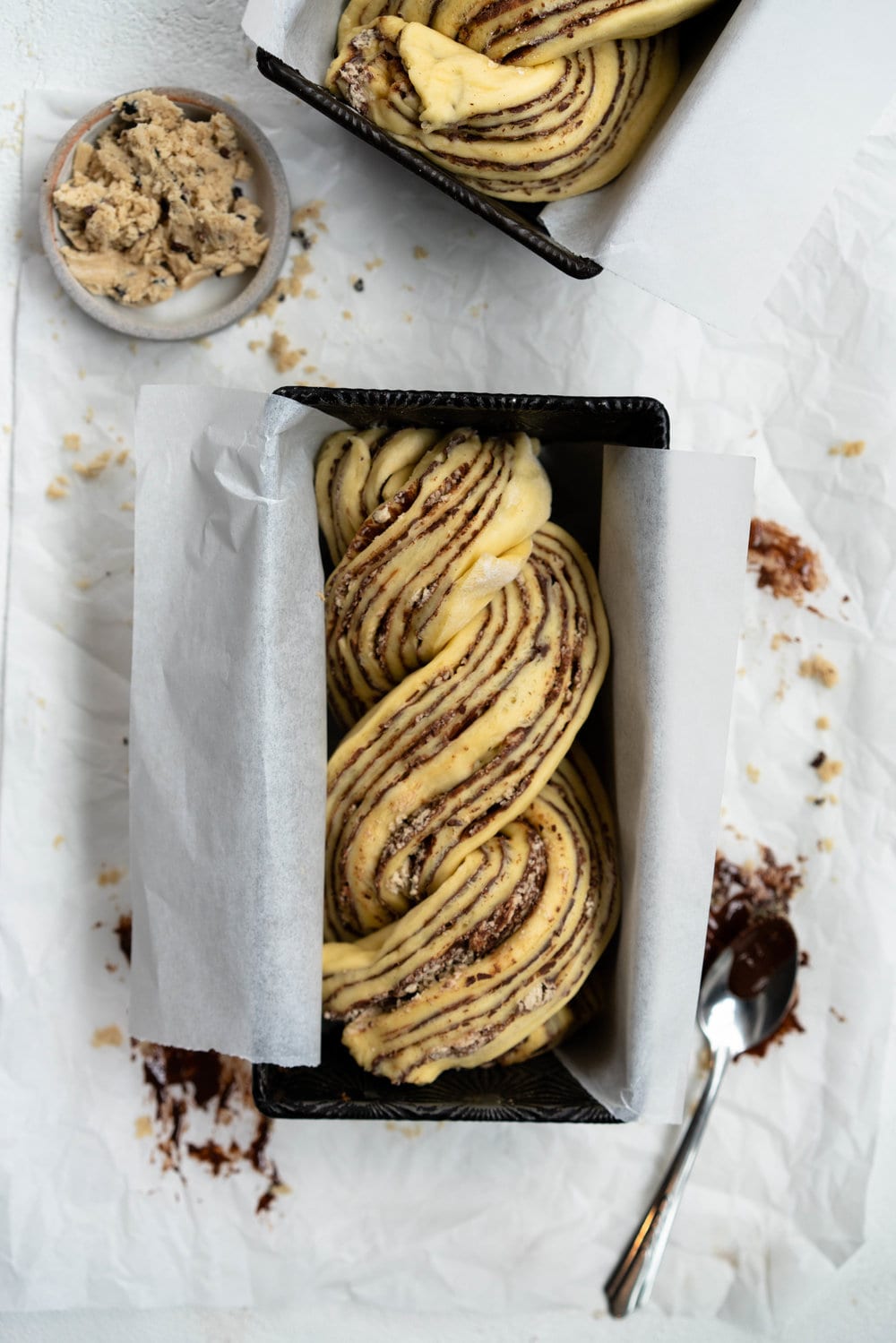 Dark Chocolate, Tahini, and Halva Brioche Babka. Fluffy brioche dough is spread with a dark chocolate tahini filling and sprinkled with halva, then rolled up and turned into the most perfect twisty bread. Perfect for a delicious breakfast or a snack with a coffee. #babka #brioche #tahini #halva