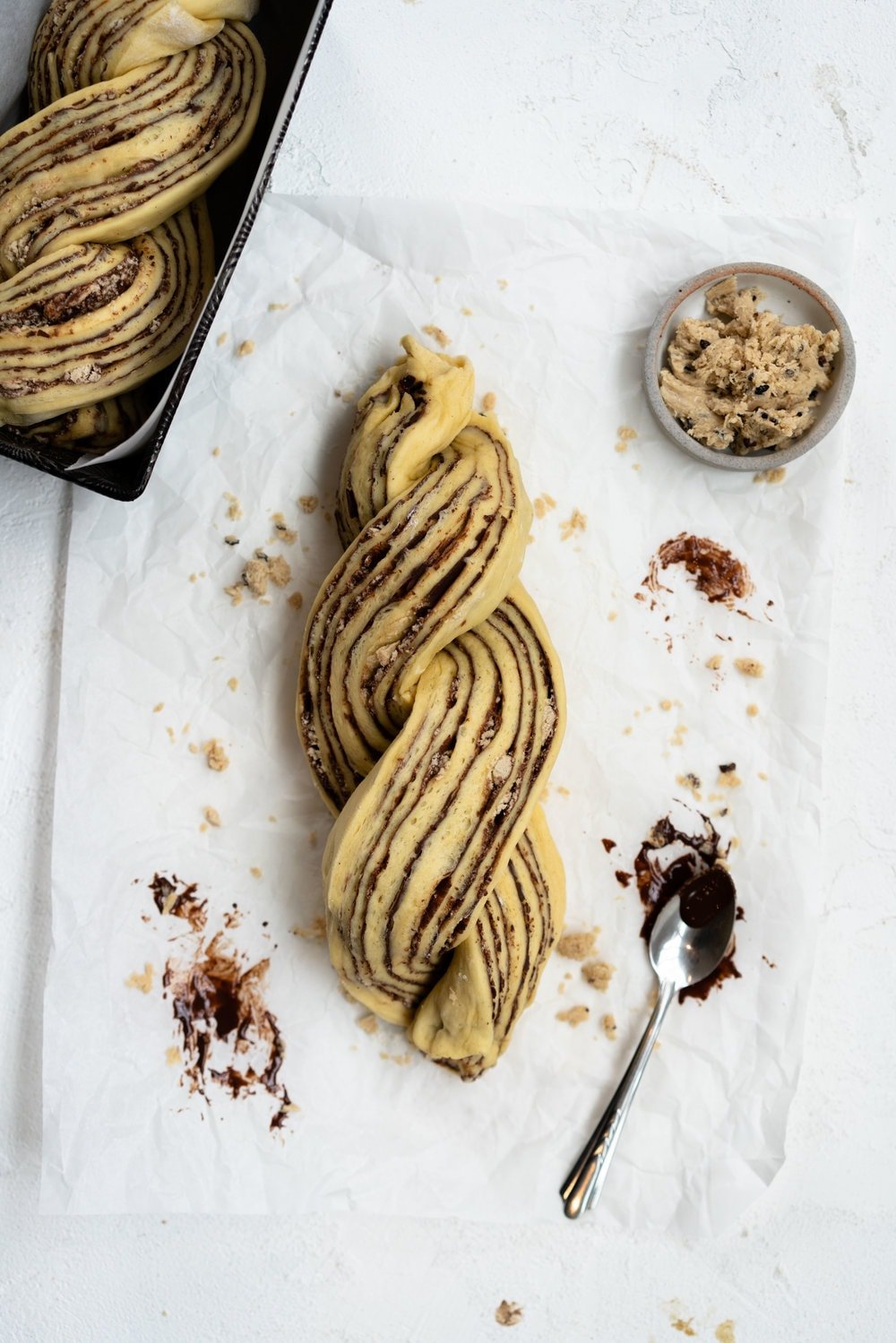 Dark Chocolate, Tahini, and Halva Brioche Babka. Fluffy brioche dough is spread with a dark chocolate tahini filling and sprinkled with halva, then rolled up and turned into the most perfect twisty bread. Perfect for a delicious breakfast or a snack with a coffee. #babka #brioche #tahini #halva
