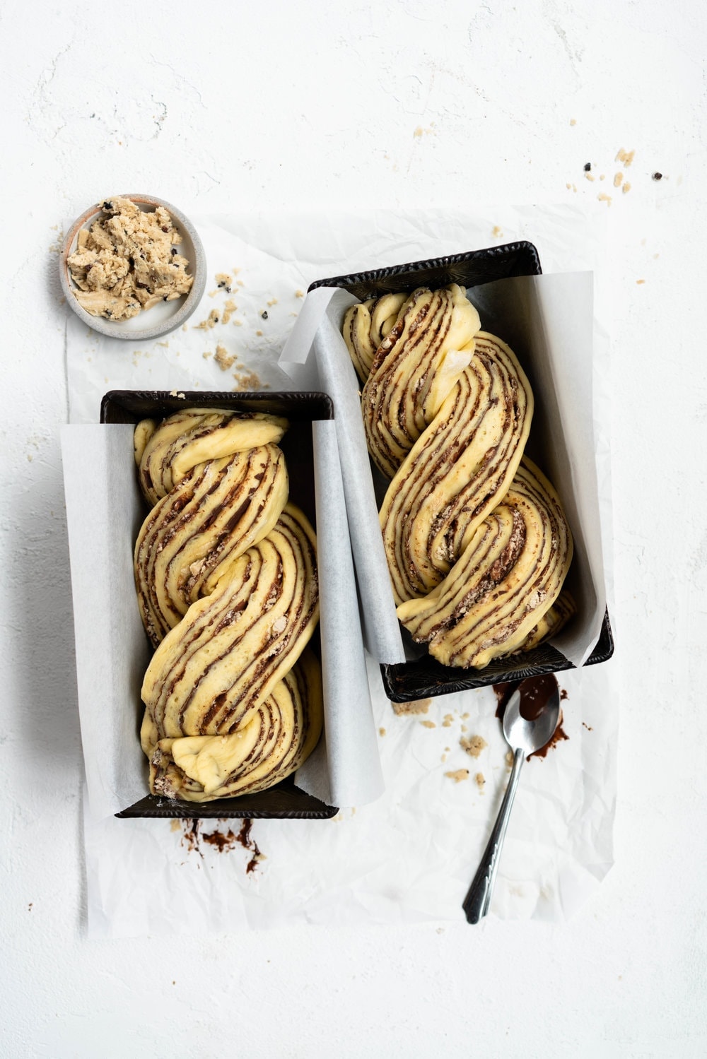 Dark Chocolate, Tahini, and Halva Brioche Babka. Fluffy brioche dough is spread with a dark chocolate tahini filling and sprinkled with halva, then rolled up and turned into the most perfect twisty bread. Perfect for a delicious breakfast or a snack with a coffee. #babka #brioche #tahini #halva