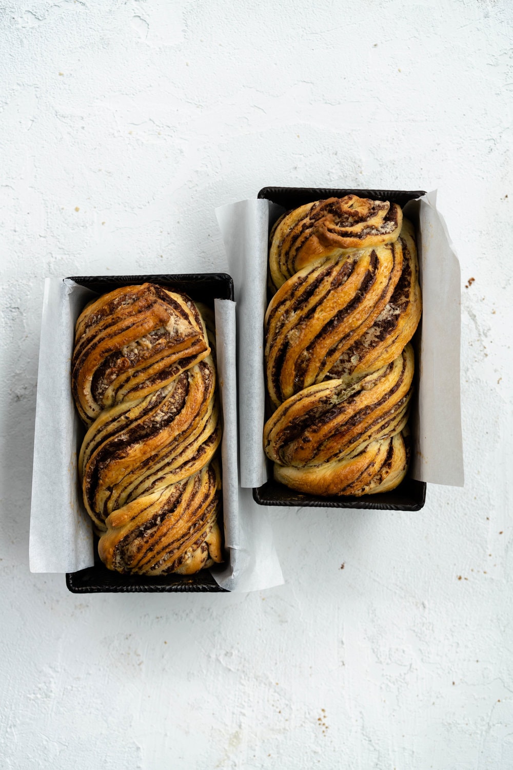 Dark Chocolate, Tahini, and Halva Brioche Babka. Fluffy brioche dough is spread with a dark chocolate tahini filling and sprinkled with halva, then rolled up and turned into the most perfect twisty bread. Perfect for a delicious breakfast or a snack with a coffee. #babka #brioche #tahini #halva