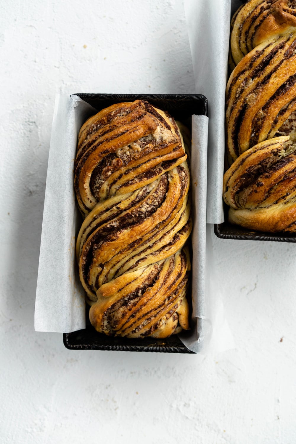 Dark Chocolate, Tahini, and Halva Brioche Babka. Fluffy brioche dough is spread with a dark chocolate tahini filling and sprinkled with halva, then rolled up and turned into the most perfect twisty bread. Perfect for a delicious breakfast or a snack with a coffee. #babka #brioche #tahini #halva