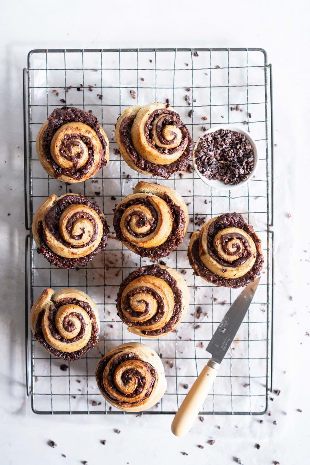 Earl Grey Buns with Dark Chocolate and Cocoa Nib Filling. Fluffy brioche dough is filled with an earl grey dark chocolate custard, and a crunchy cacao nib filling, then rolled up and sliced into buns. Once baked, the rolls are brushed with butter and rolled in a cocoa nib earl grey sugar. Rich and indulgent, and the most perfect treat. #earlgreybuns #chocolatebuns #earlgreycustard