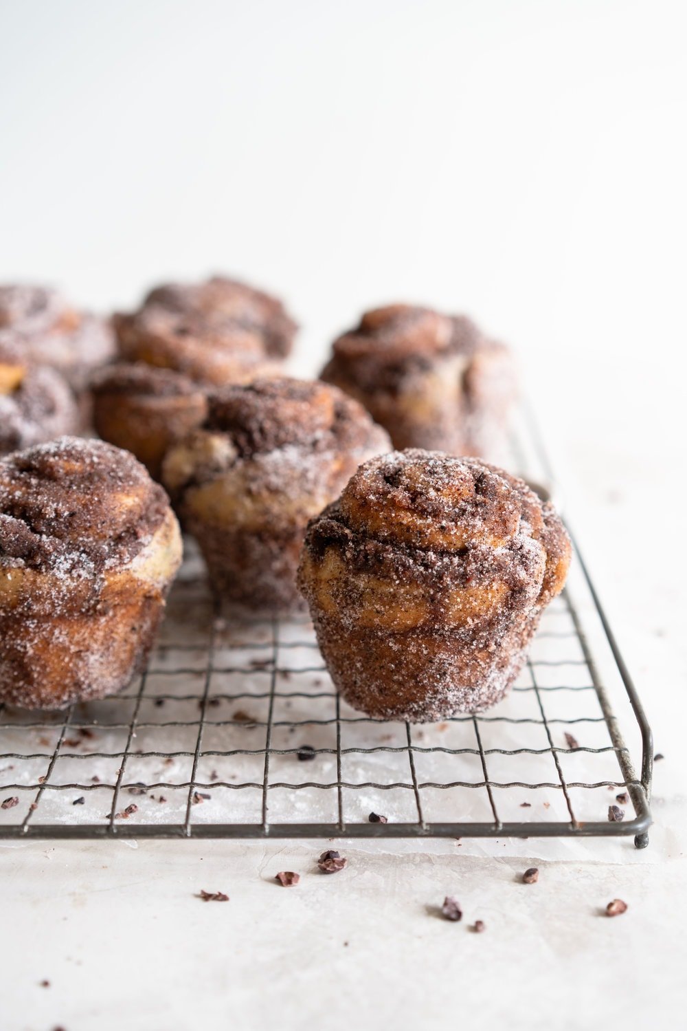 Earl Grey Buns with Dark Chocolate and Cocoa Nib Filling. Fluffy brioche dough is filled with an earl grey dark chocolate custard, and a crunchy cacao nib filling, then rolled up and sliced into buns. Once baked, the rolls are brushed with butter and rolled in a cocoa nib earl grey sugar. Rich and indulgent, and the most perfect treat. #earlgreybuns #chocolatebuns #earlgreycustard