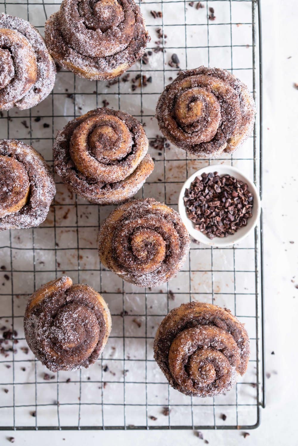 Earl Grey Buns with Dark Chocolate and Cocoa Nib Filling. Fluffy brioche dough is filled with an earl grey dark chocolate custard, and a crunchy cacao nib filling, then rolled up and sliced into buns. Once baked, the rolls are brushed with butter and rolled in a cocoa nib earl grey sugar. Rich and indulgent, and the most perfect treat. #earlgreybuns #chocolatebuns #earlgreycustard