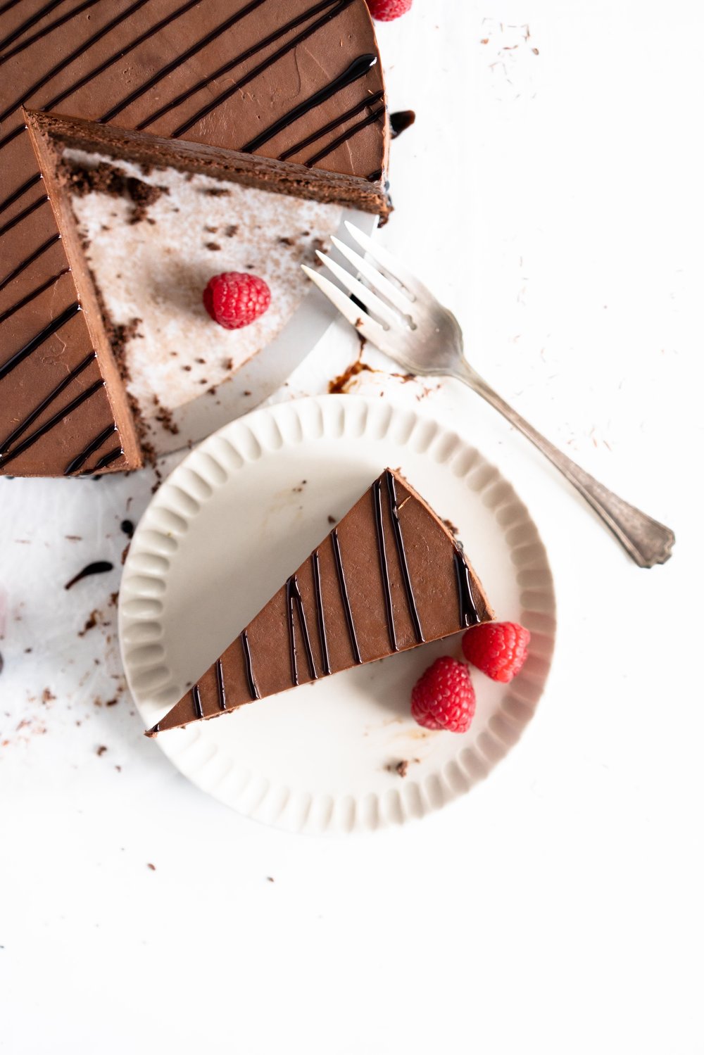 No Bake Chocolate Cheesecake - a chocolate graham cracker base is topped with a silky, no bake chocolate cheesecake filling, and finished with a drizzle of sweet, sticky raspberry balsamic glaze. This dessert comes together quickly, and is perfect for feeding a crowd. #cheesecake #chocolatecheesecake #nobakecheesecake