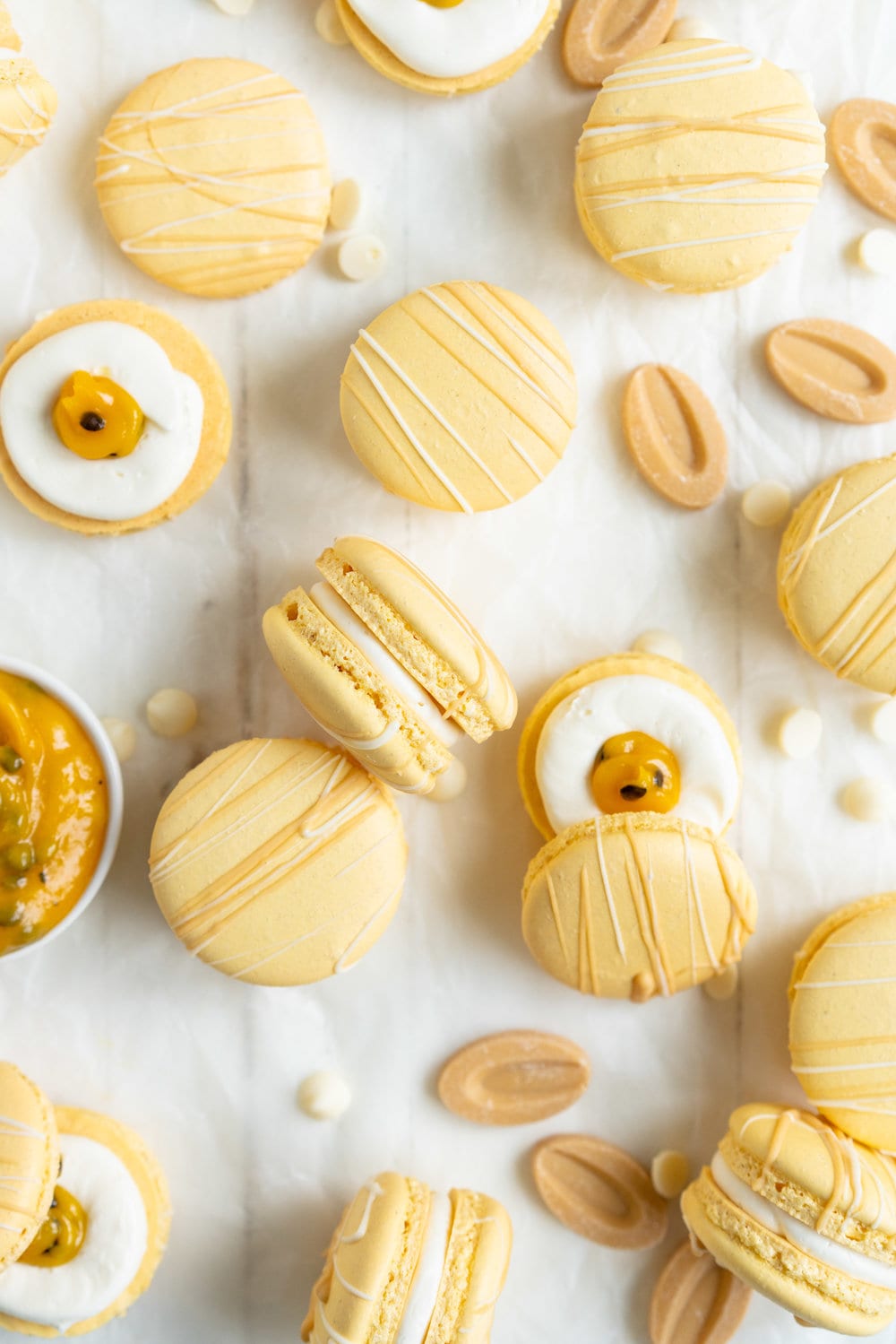 Passionfruit and White Chocolate Macarons - Vanilla bean macaron shell, filled with white chocolate swiss meringue buttercream and tangy passionfruit curd, then finished with a chocolate drizzle. #frenchmacaron #macarons #passionfruit
