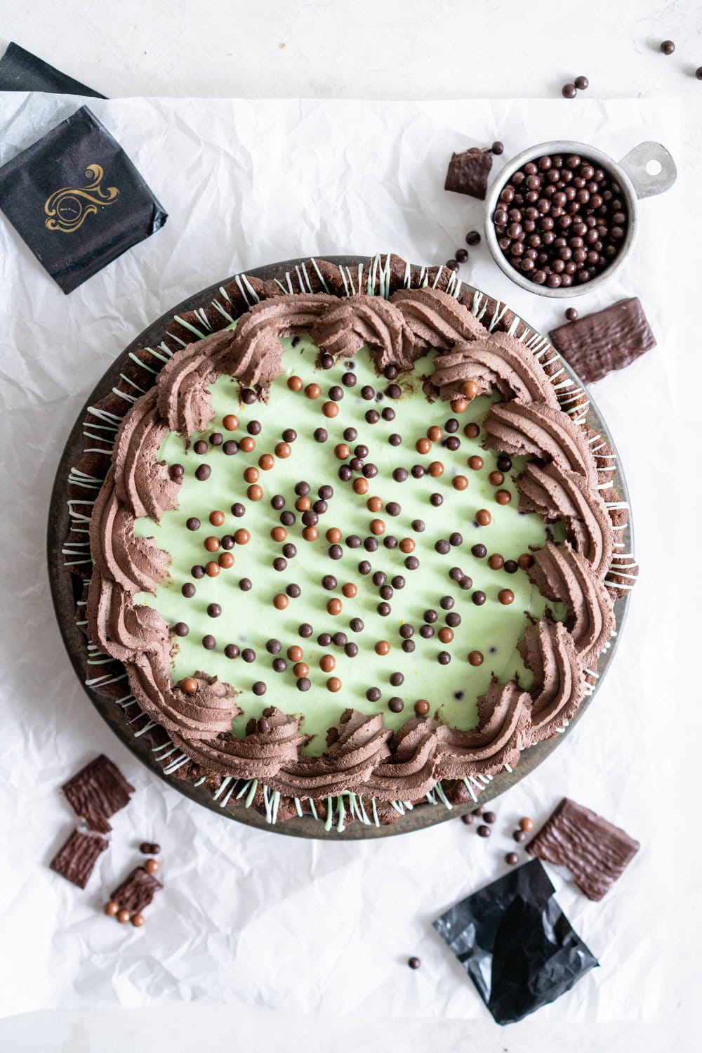Double Chocolate Mint Chip Pie from 'The New Pie'. Chocolate pastry is drizzled with white and green chocolate, filled with a dark chocolate ganache, topped with chopped mints, then topped with a mint chocolate chip cream filling loaded up with crispy pearls. The whole thing is then finished with a cocoa whipped cream. If there was a pie version of the perfect scoop of mint chocolate chip ice cream, this pie would be it. #mintchip #doublechocolate #creampie
