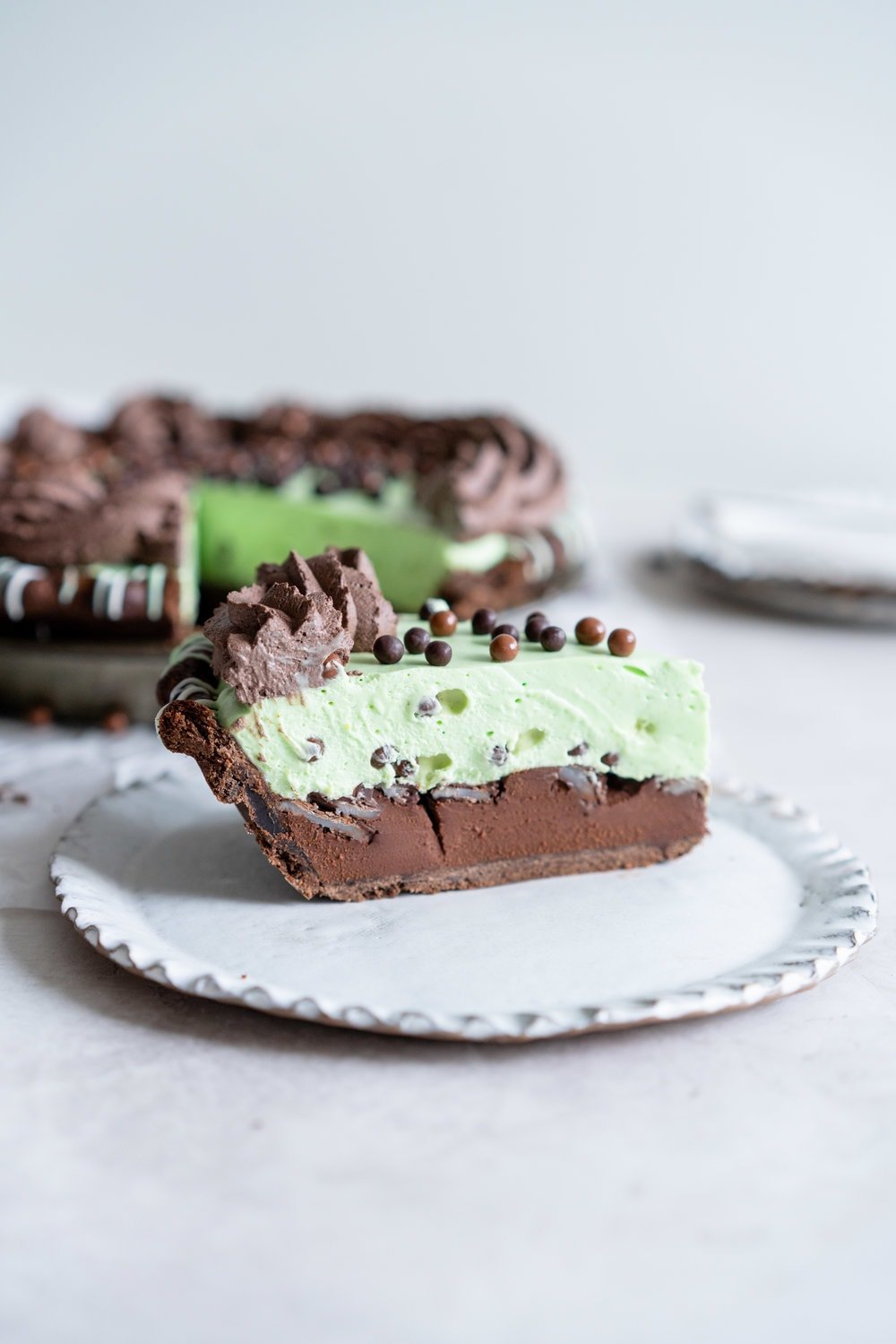 Double Chocolate Mint Chip Pie from 'The New Pie'. Chocolate pastry is drizzled with white and green chocolate, filled with a dark chocolate ganache, topped with chopped mints, then topped with a mint chocolate chip cream filling loaded up with crispy pearls. The whole thing is then finished with a cocoa whipped cream. If there was a pie version of the perfect scoop of mint chocolate chip ice cream, this pie would be it. #mintchip #doublechocolate #creampie