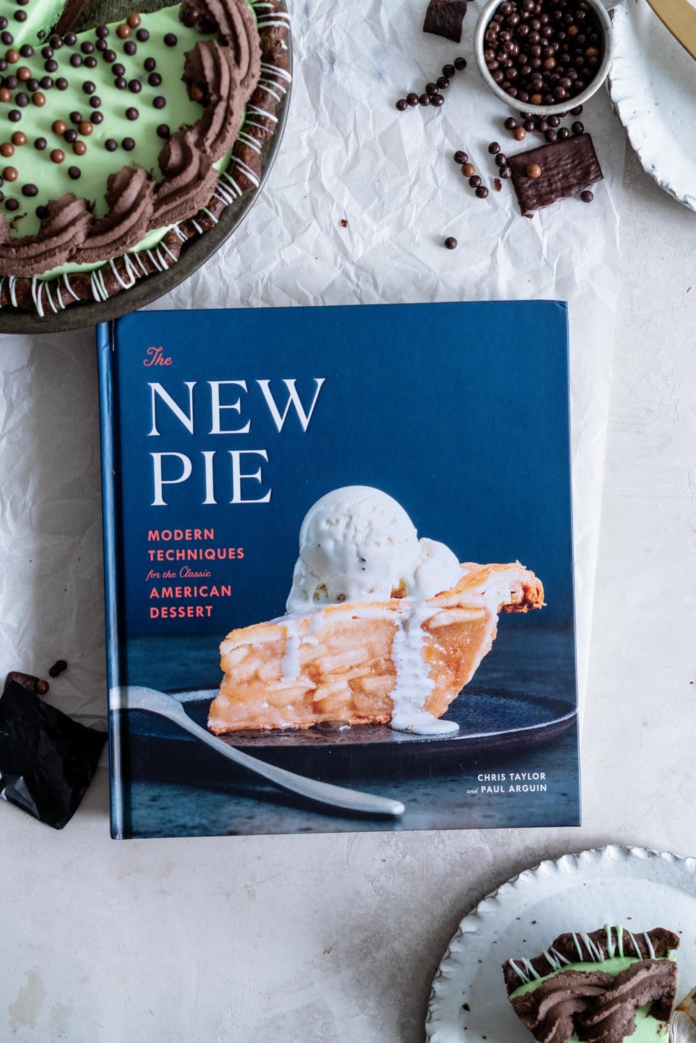 Double Chocolate Mint Chip Pie from 'The New Pie'. Chocolate pastry is drizzled with white and green chocolate, filled with a dark chocolate ganache, topped with chopped mints, then topped with a mint chocolate chip cream filling loaded up with crispy pearls. The whole thing is then finished with a cocoa whipped cream. If there was a pie version of the perfect scoop of mint chocolate chip ice cream, this pie would be it. #mintchip #doublechocolate #creampie