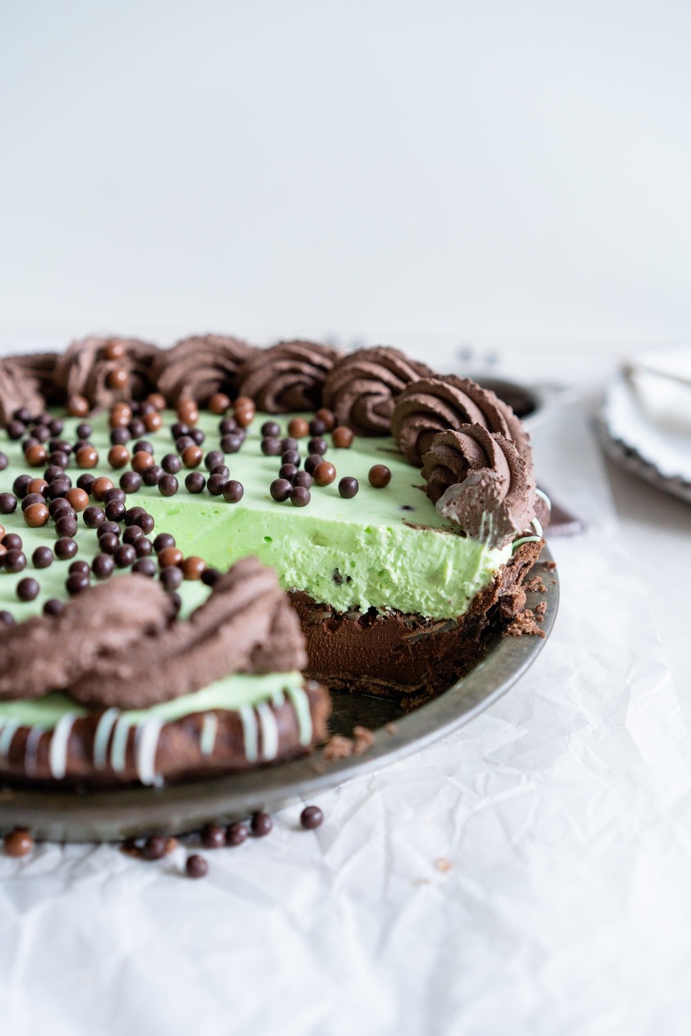 Double Chocolate Mint Chip Pie from 'The New Pie'. Chocolate pastry is drizzled with white and green chocolate, filled with a dark chocolate ganache, topped with chopped mints, then topped with a mint chocolate chip cream filling loaded up with crispy pearls. The whole thing is then finished with a cocoa whipped cream. If there was a pie version of the perfect scoop of mint chocolate chip ice cream, this pie would be it. #mintchip #doublechocolate #creampie